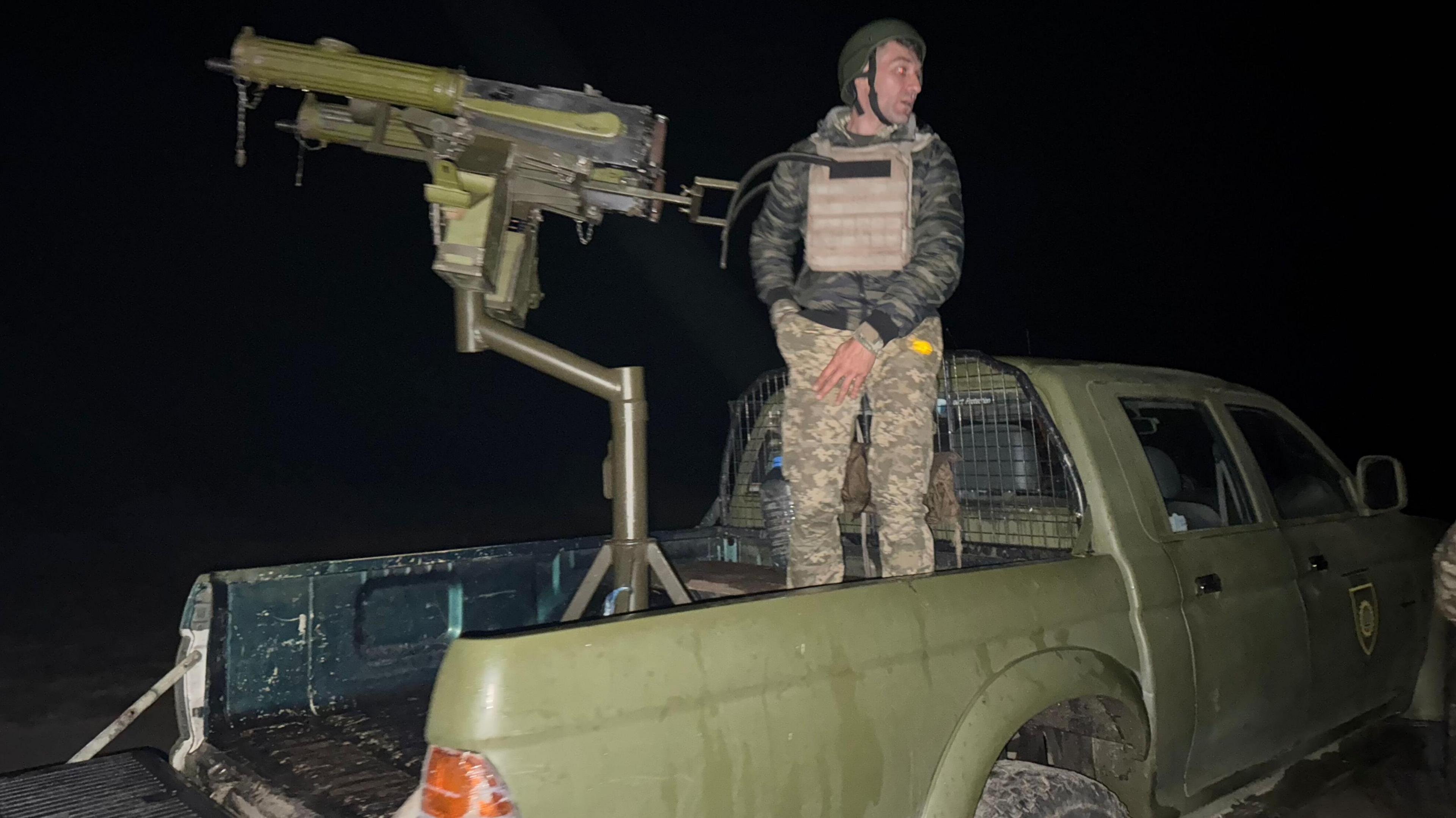 The witches - with a male colleague - mount their machine gun during the night op