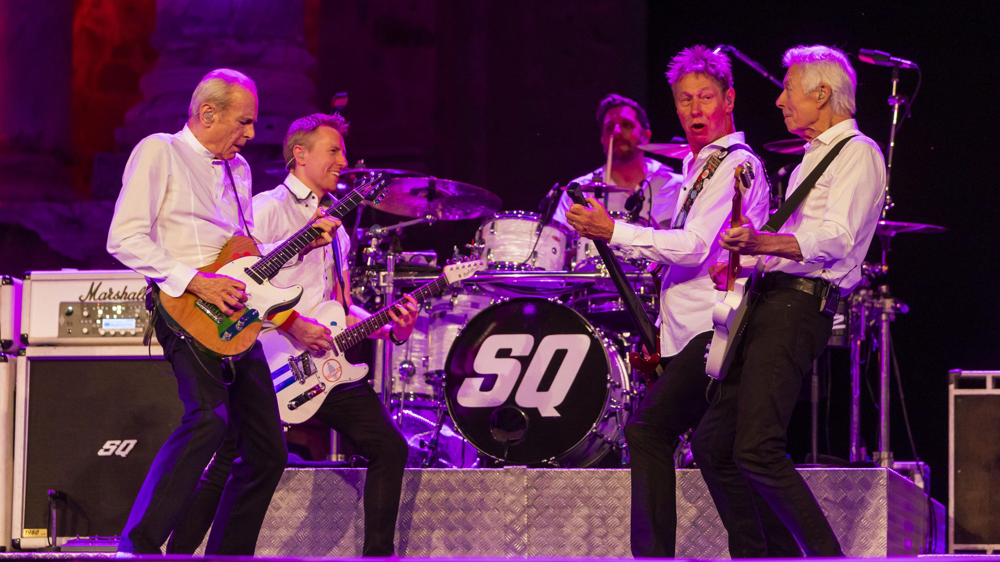 Current five members of Status Quo perform on stage