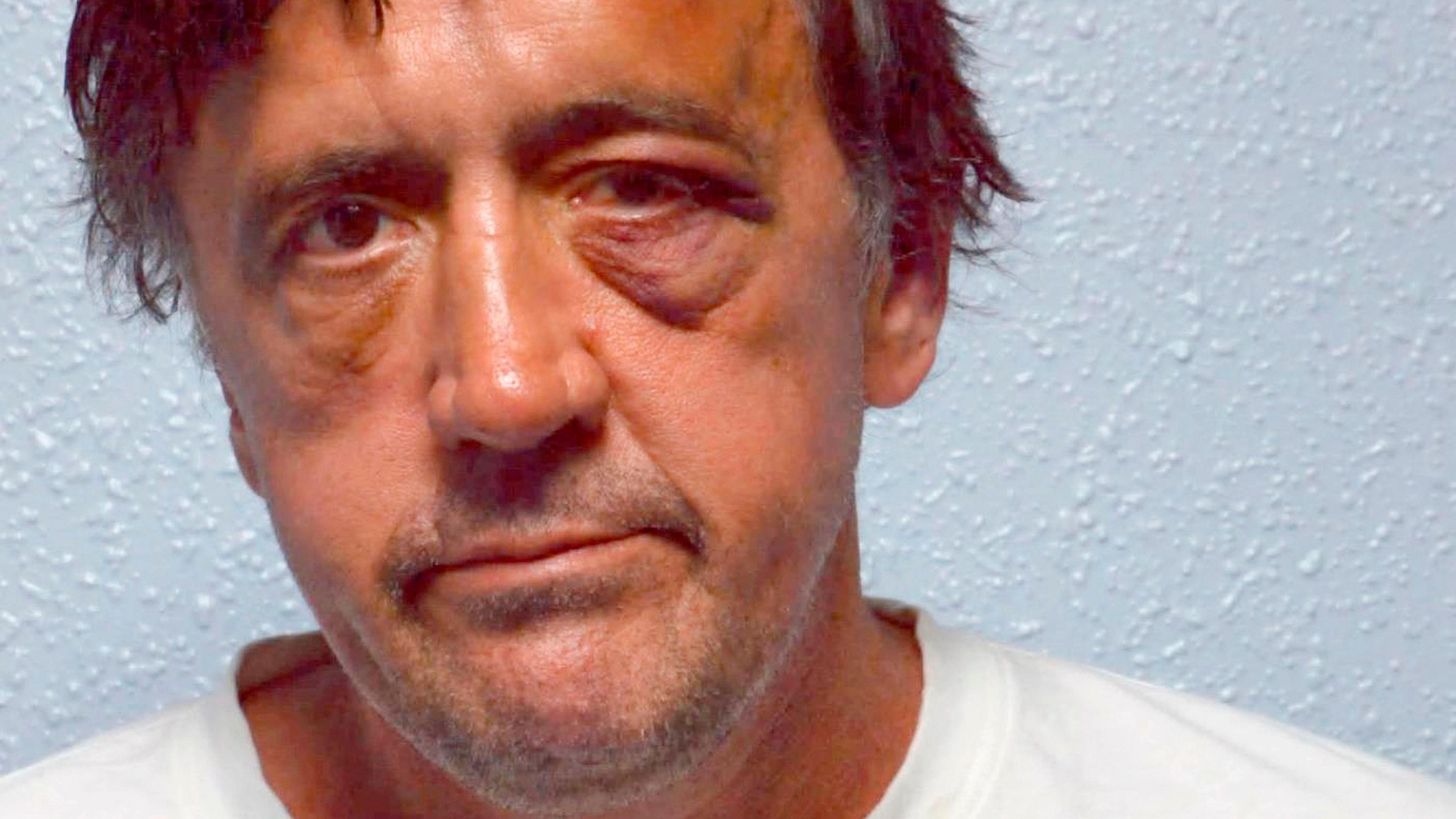 Mugshot of Darren Osborne who is unshaven and has a swollen and black left eye. He is wearing a white t-shirt.