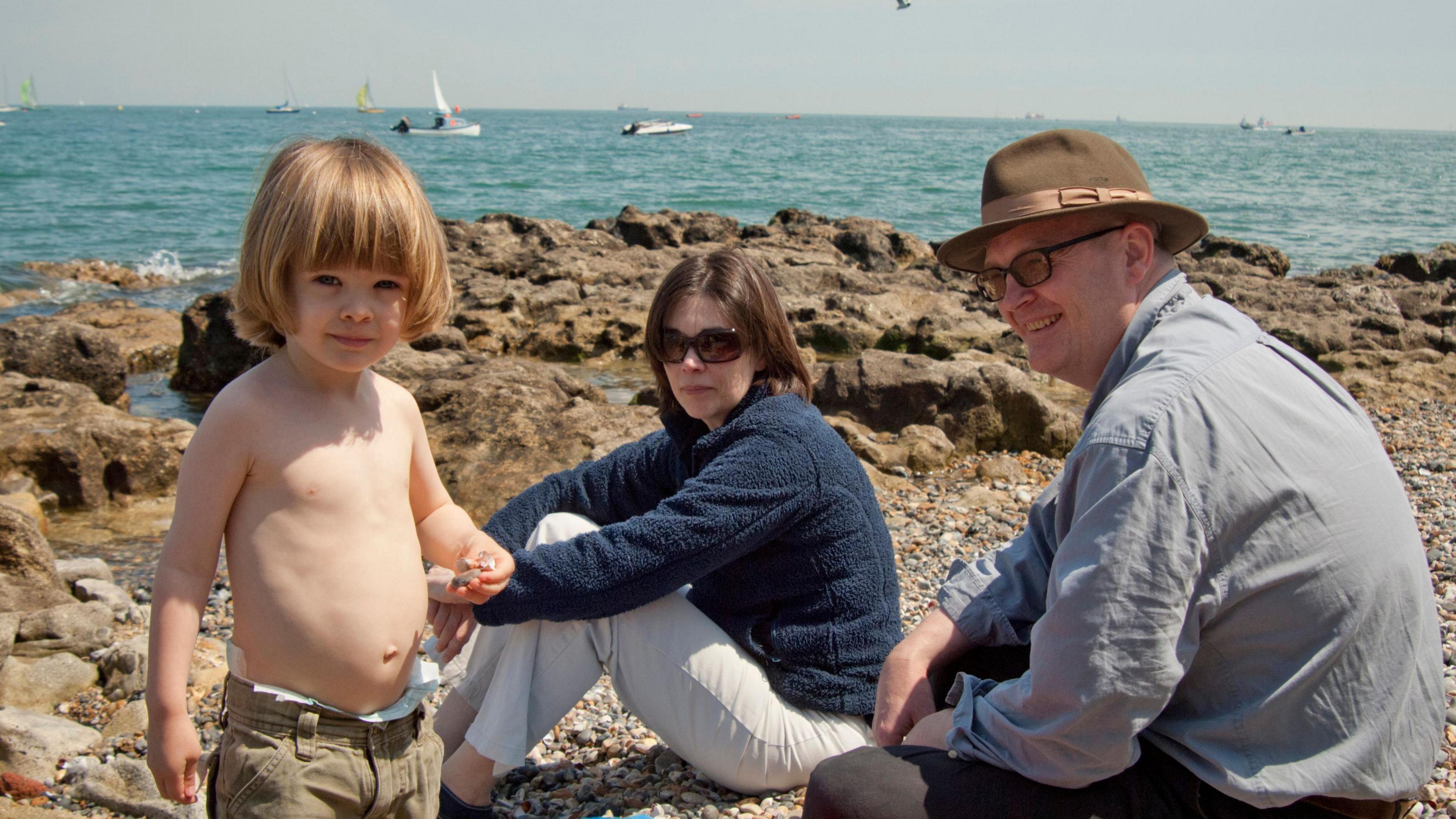 Max Prince as a toddler on the beach with his parents looking on