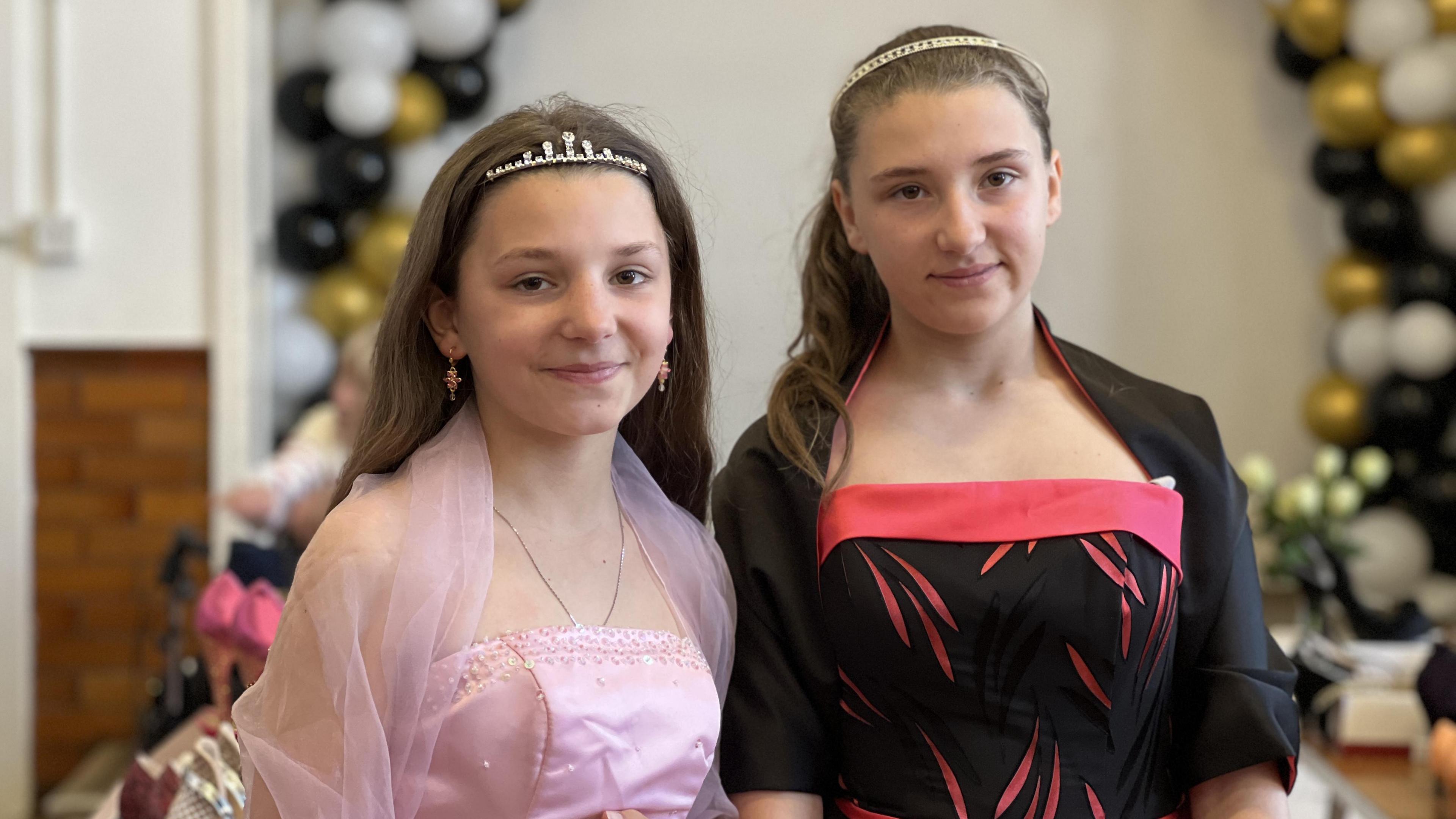 Two girls wearing prom dresses