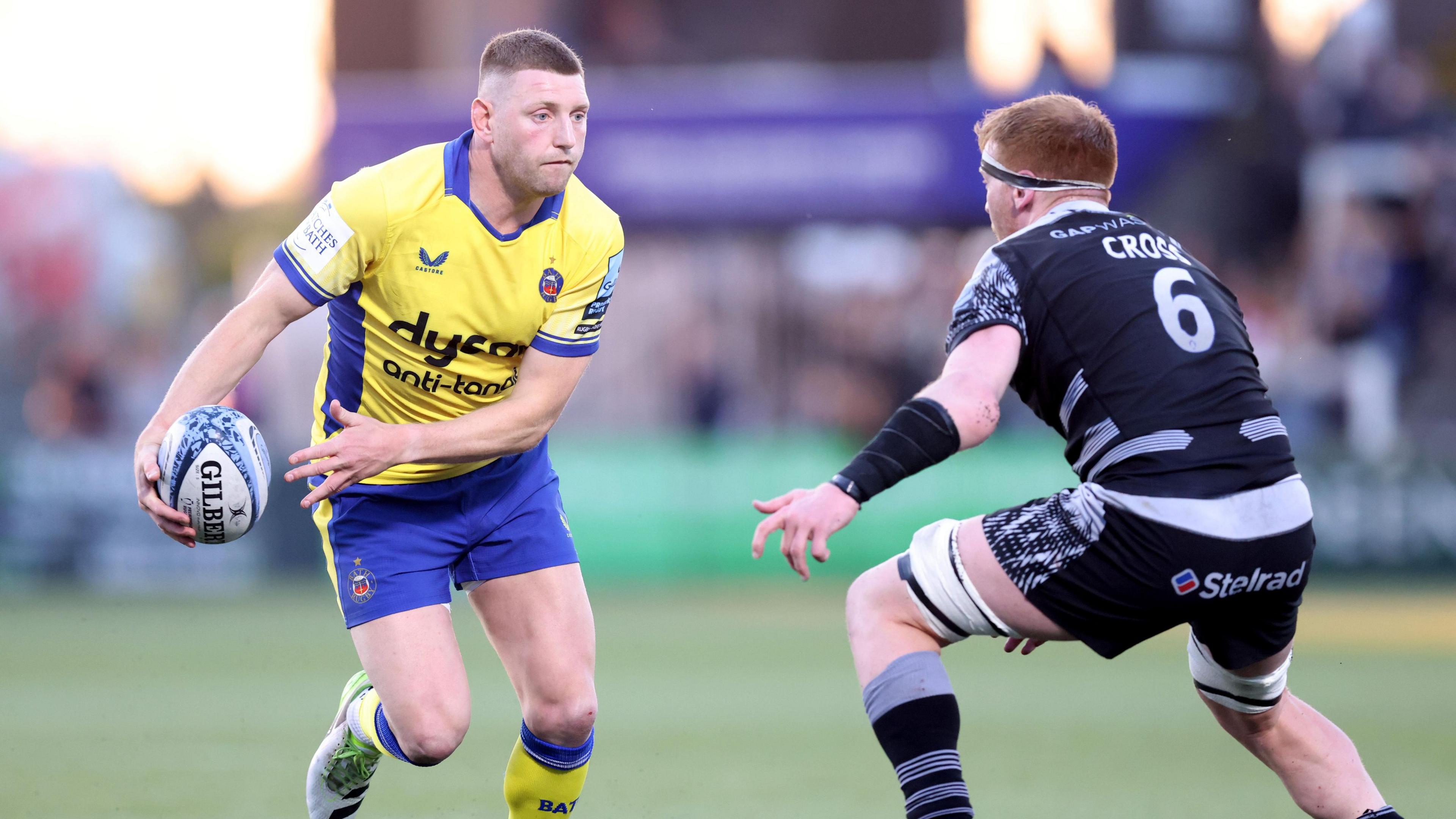 Finn Russell runs at a Newcastle player with the ball during their game