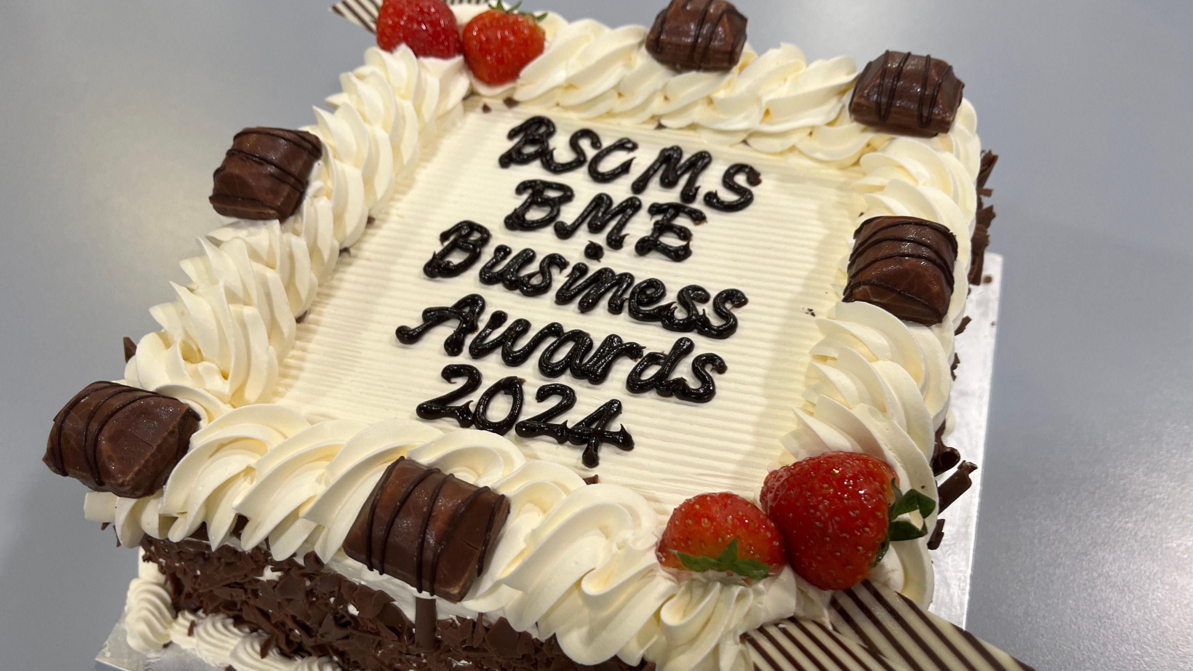 A cake with BSCMA BME Business Awards 2024 in chocolate icing