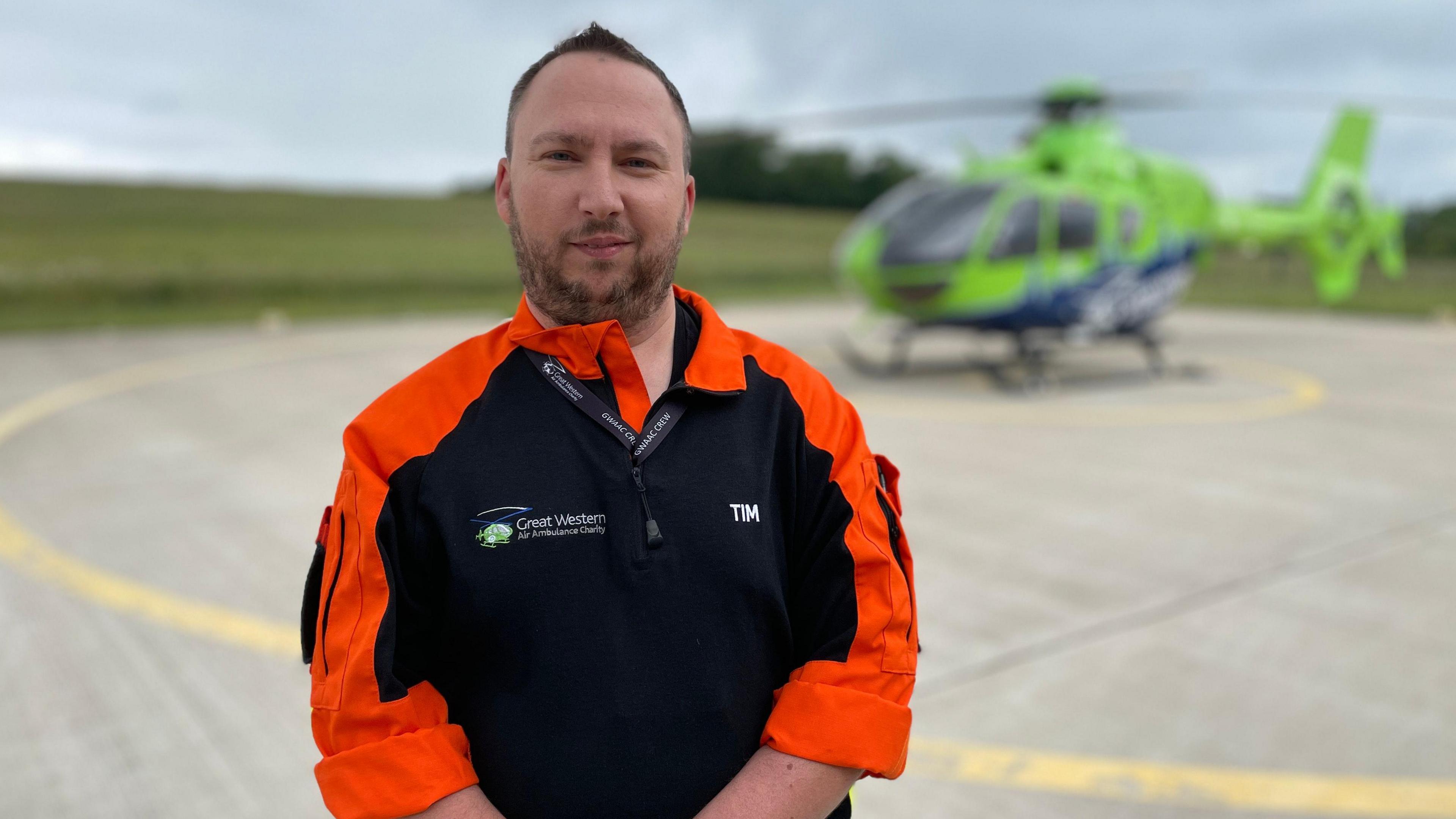 A man in uniform in front of a helicopter