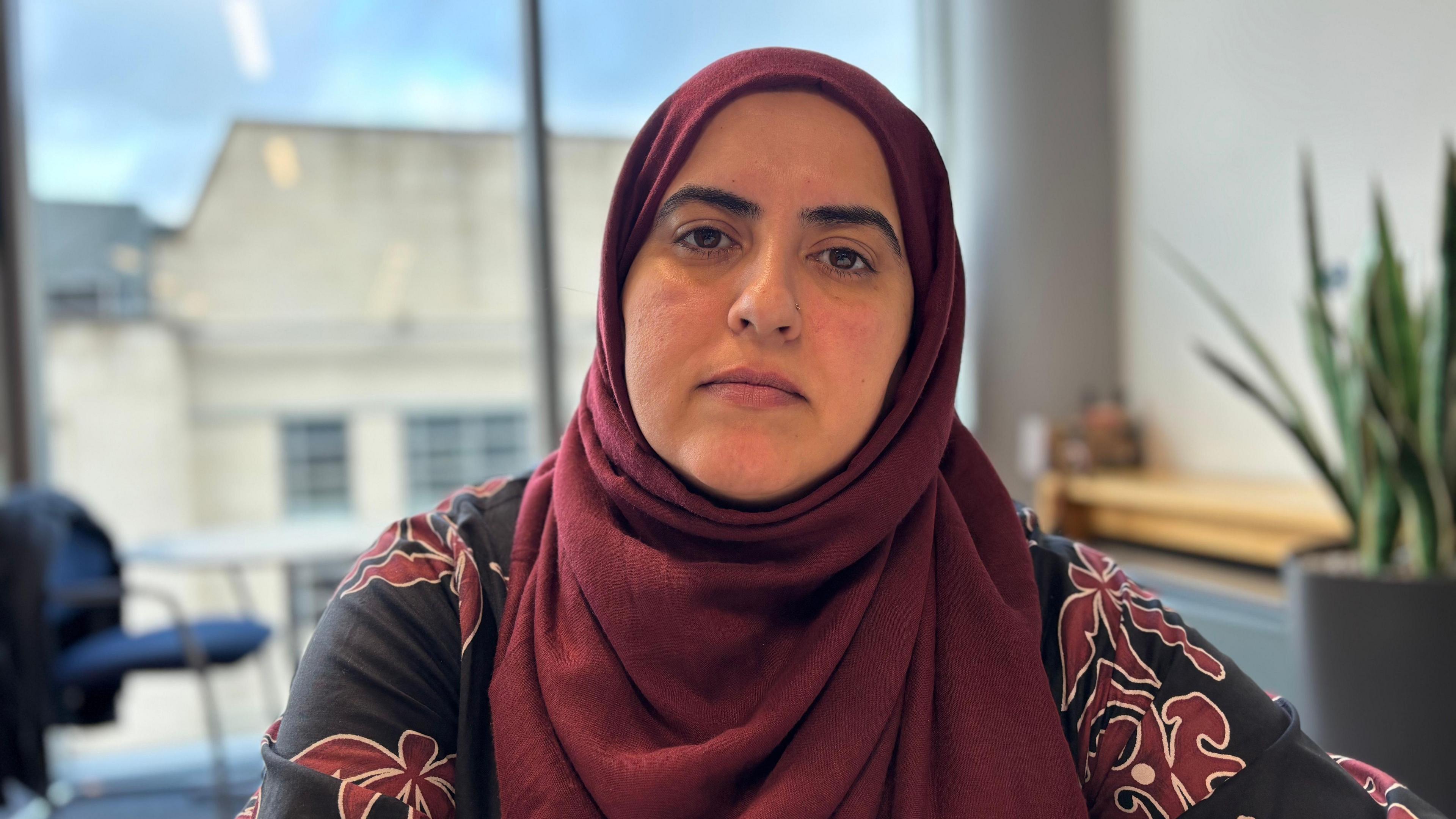 Nottingham City Council leader Neghat Khan is pictured wearing a red headscarf and black and red patterned shirt