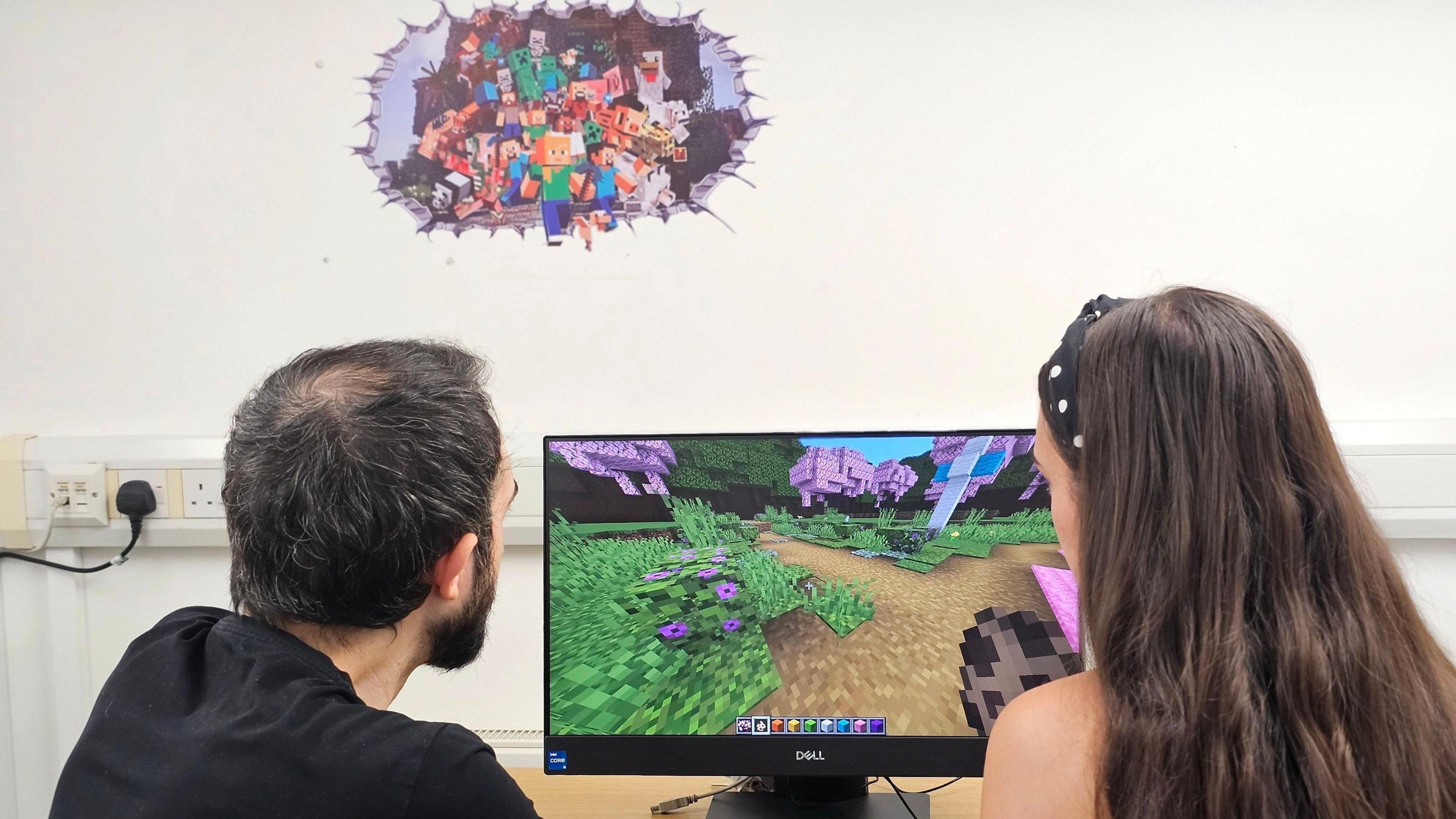 Teacher and Student sit at a computer screen with the popular game Minecraft on 