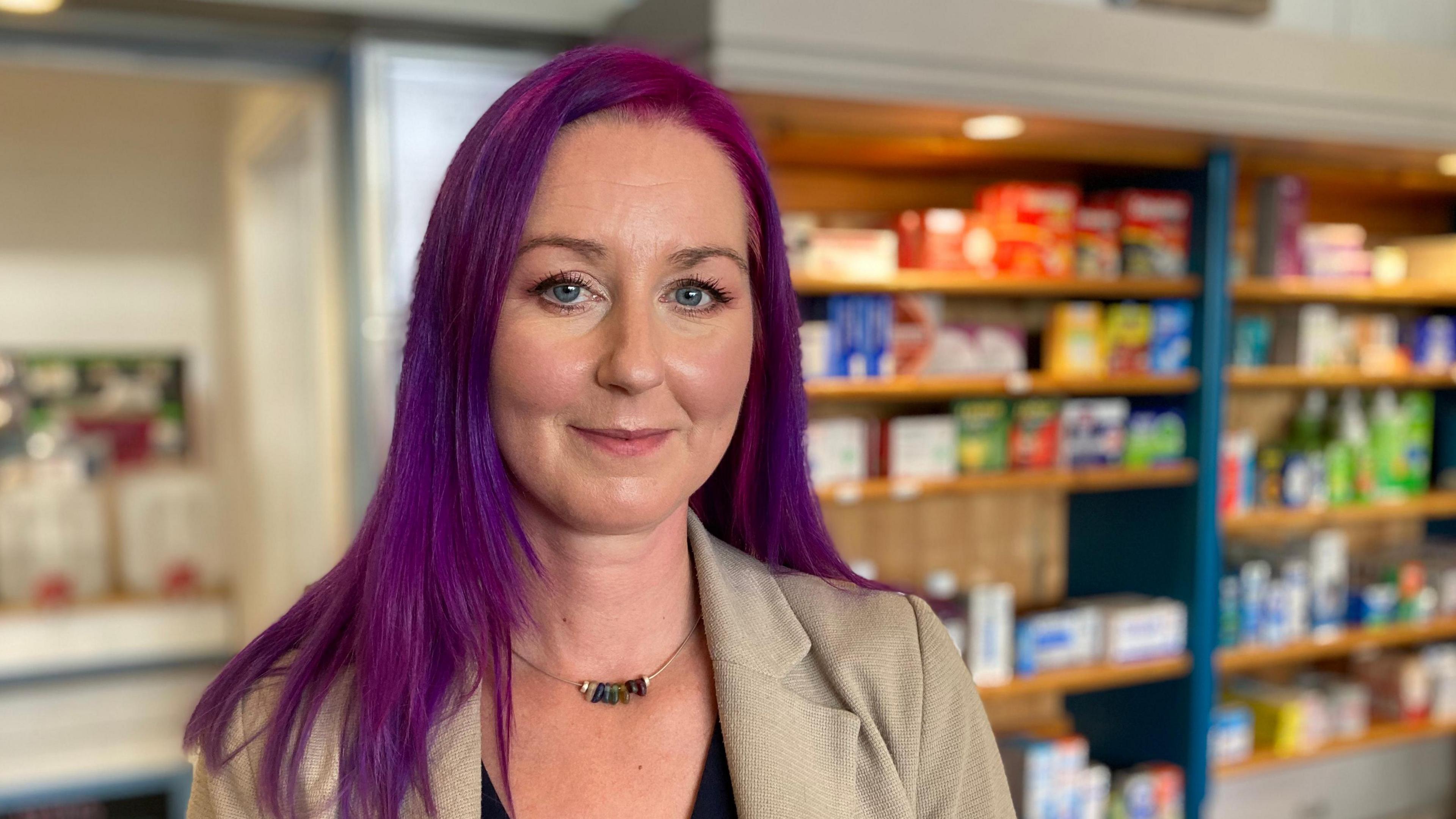 Pharmacist Jenny White in a pharmacy, smiling at the camera