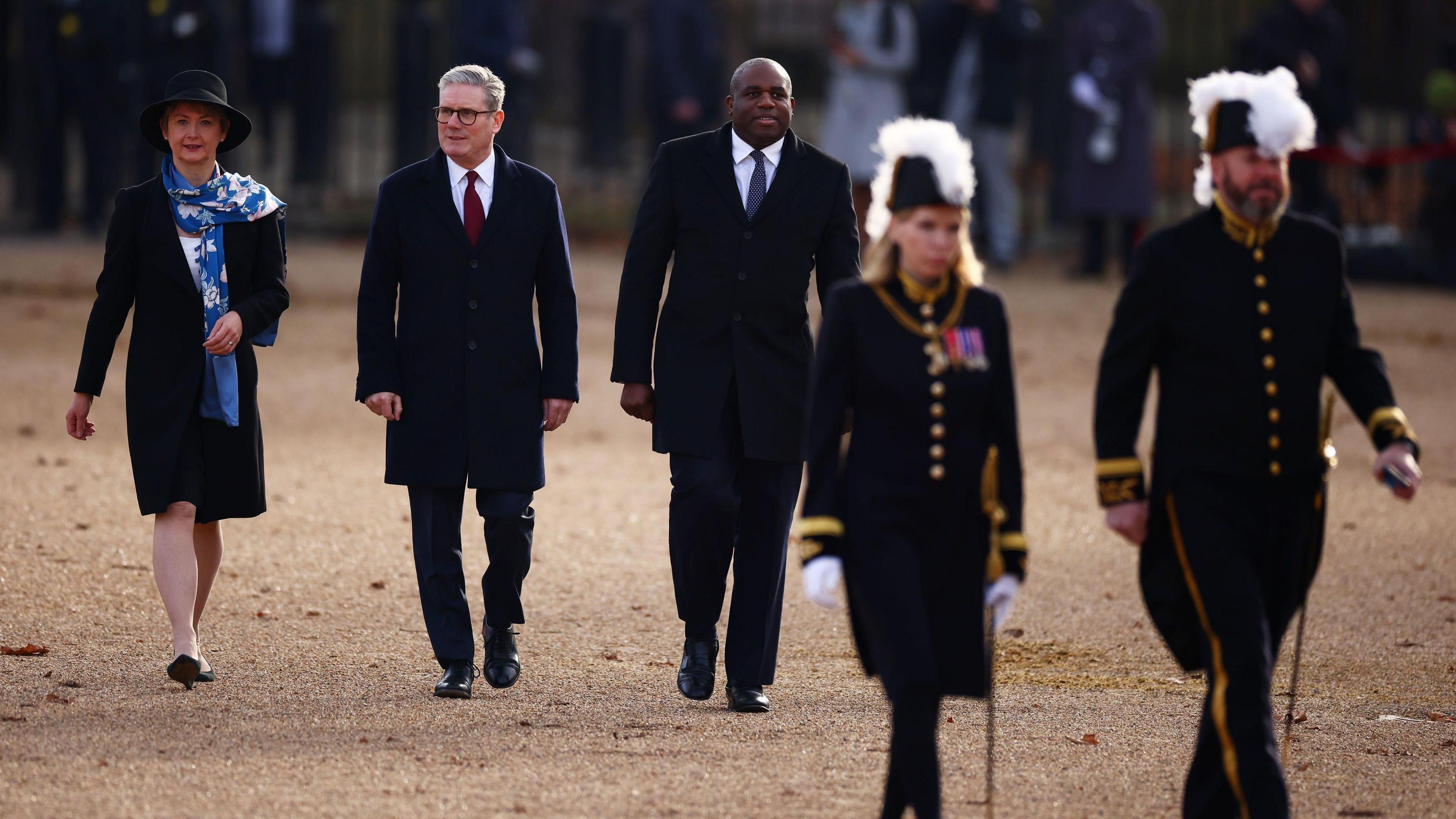 Prime Minister Keir Starmer walks in between David Lammy and Yvette Cooper along The Mall