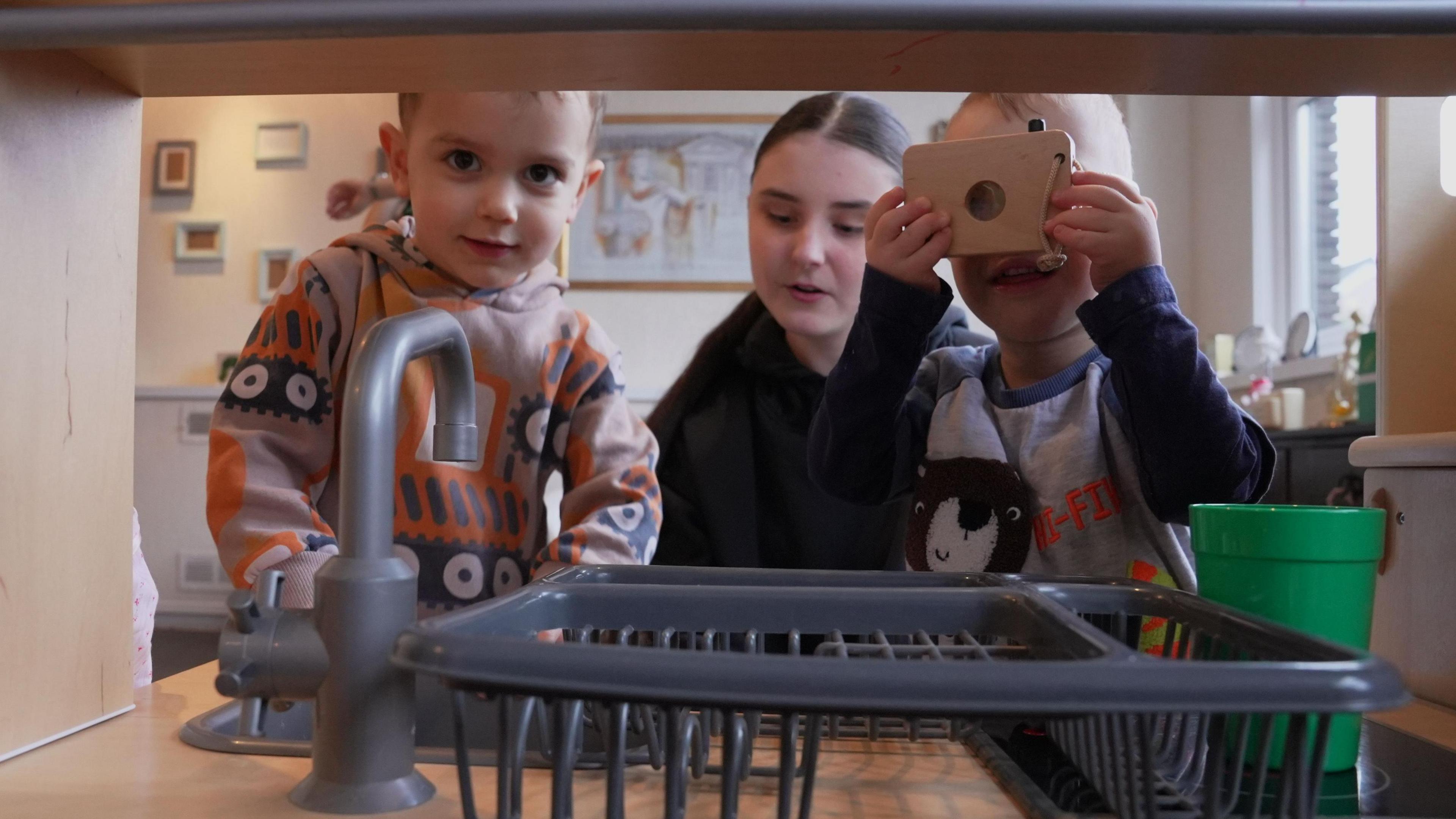 Children playing in a toy kitchen in a nursery