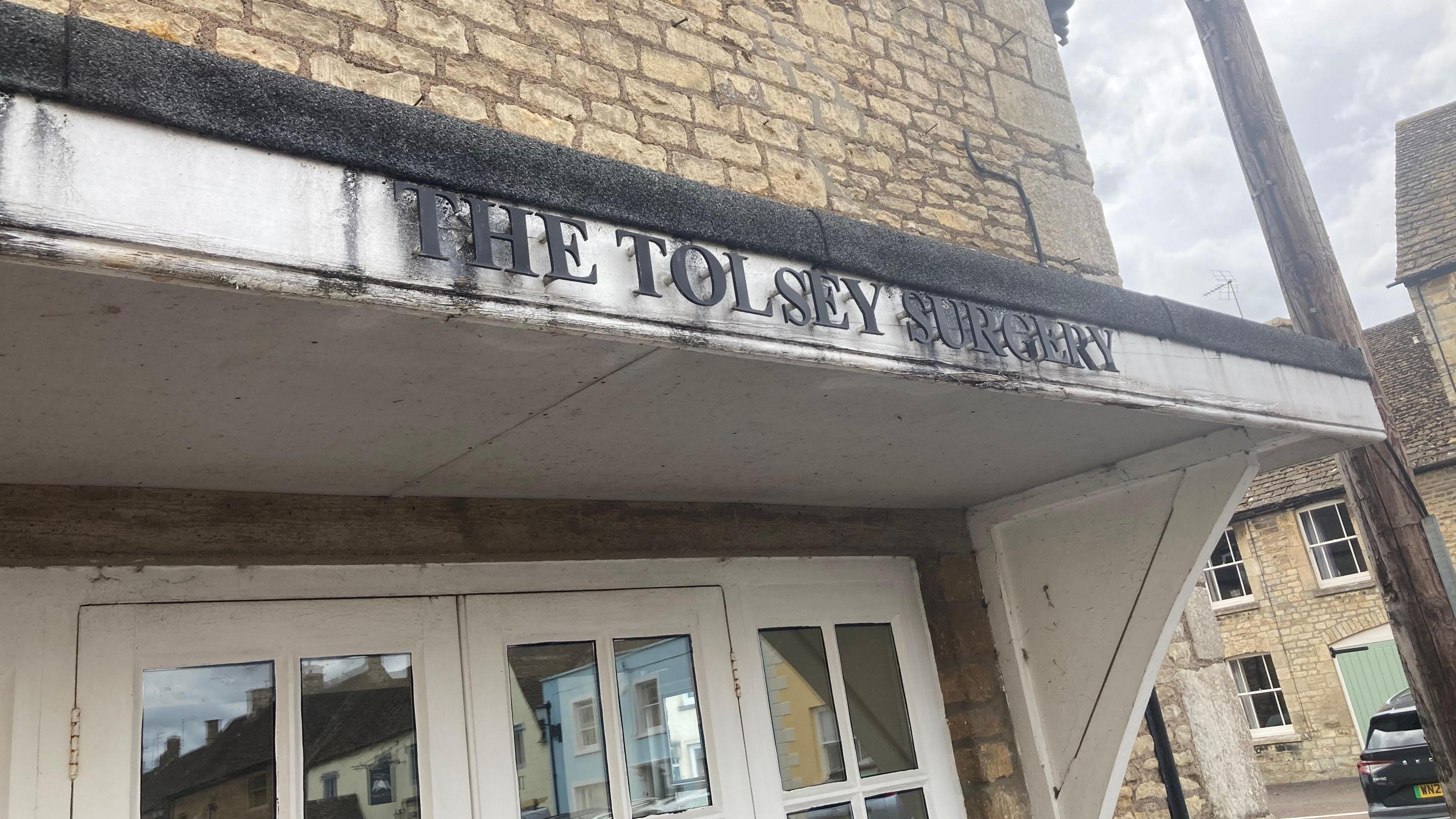 A close-up of a section of the Sherston GP building with lettering saying 'The Tolsey Surgery'