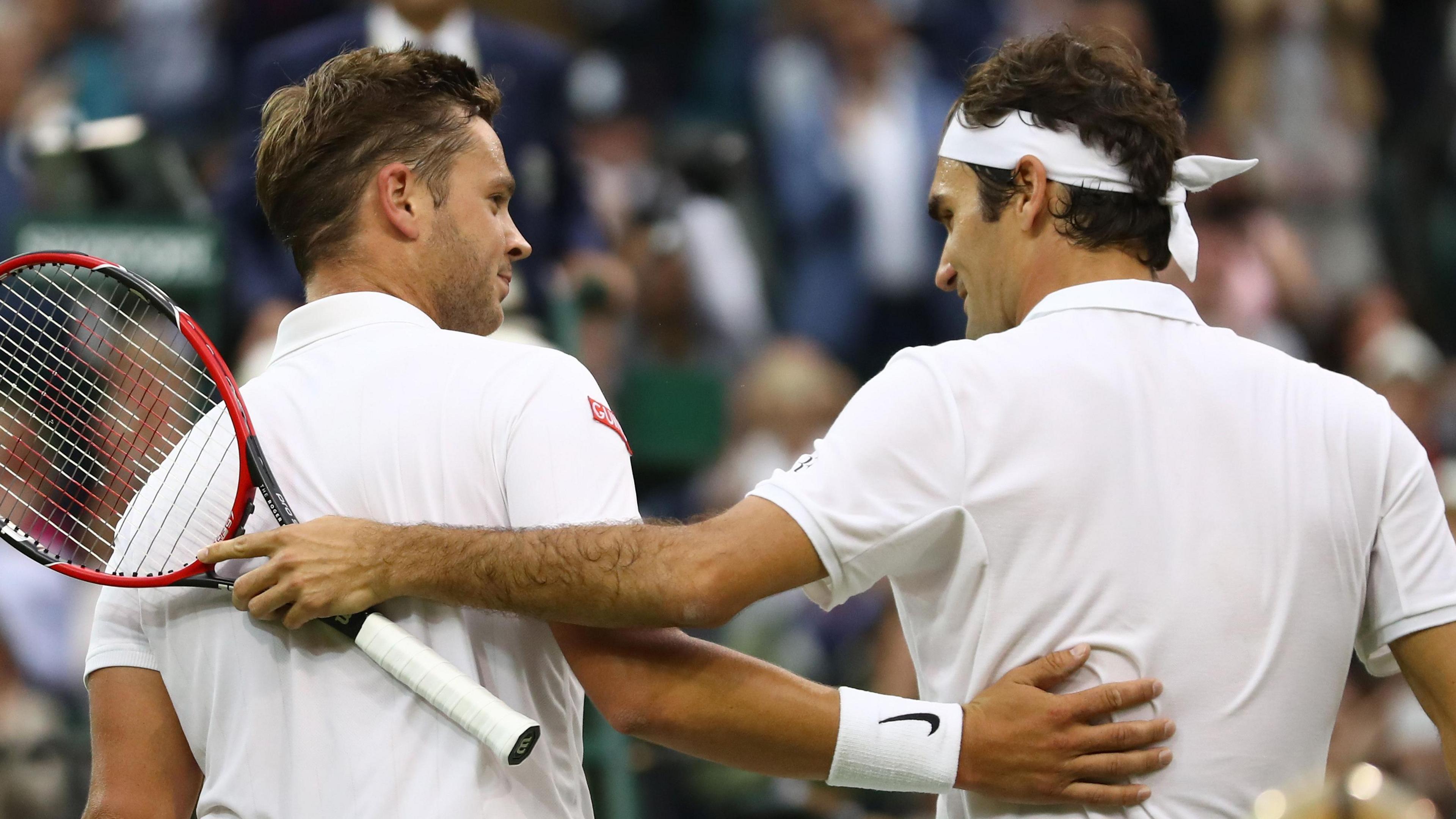 Marcus Willis embraces Roger Federer after their Centre Court match at Wimbledon on 2016