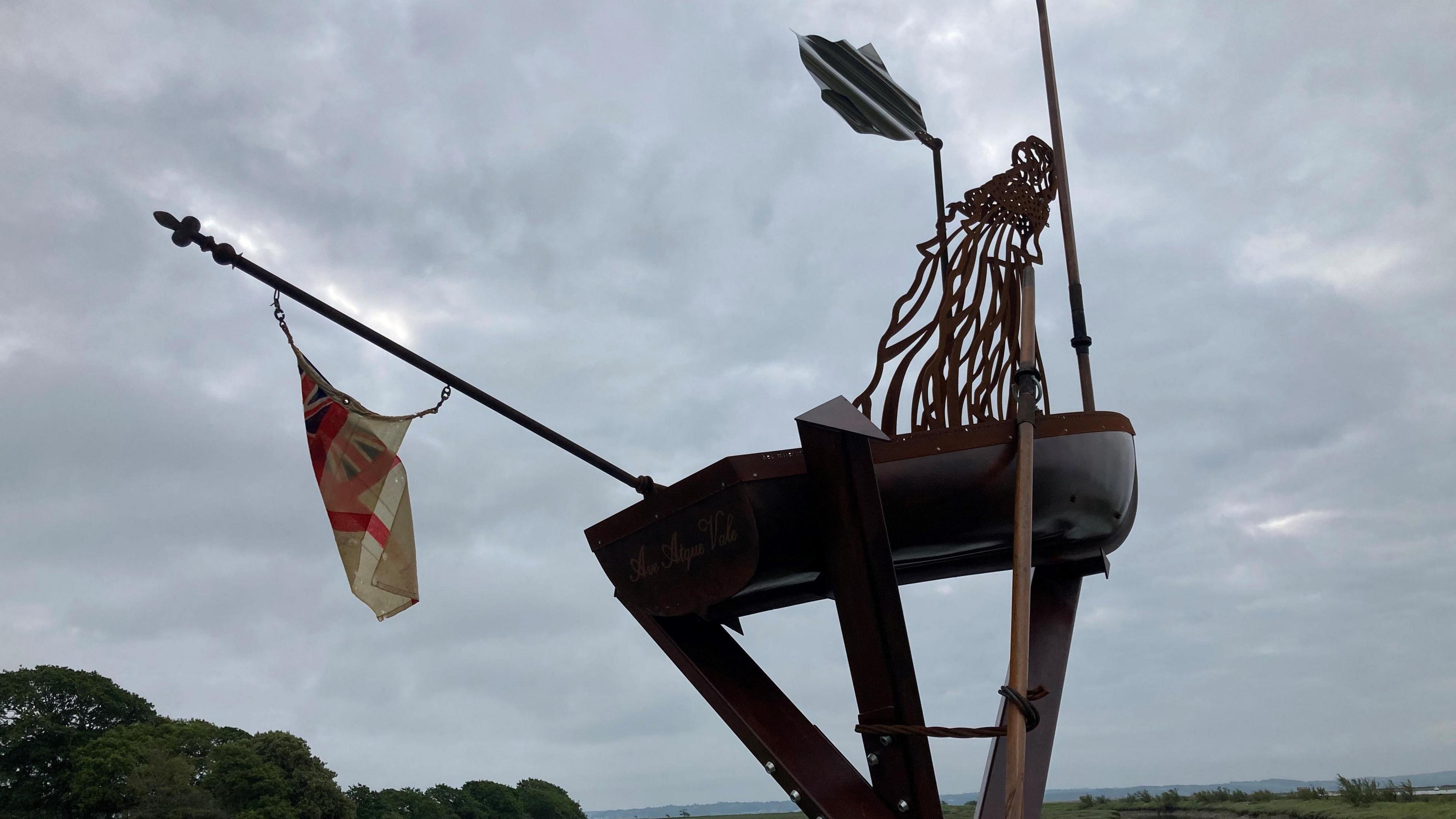 Metal sculpture represents a Wren waving a white handerchief