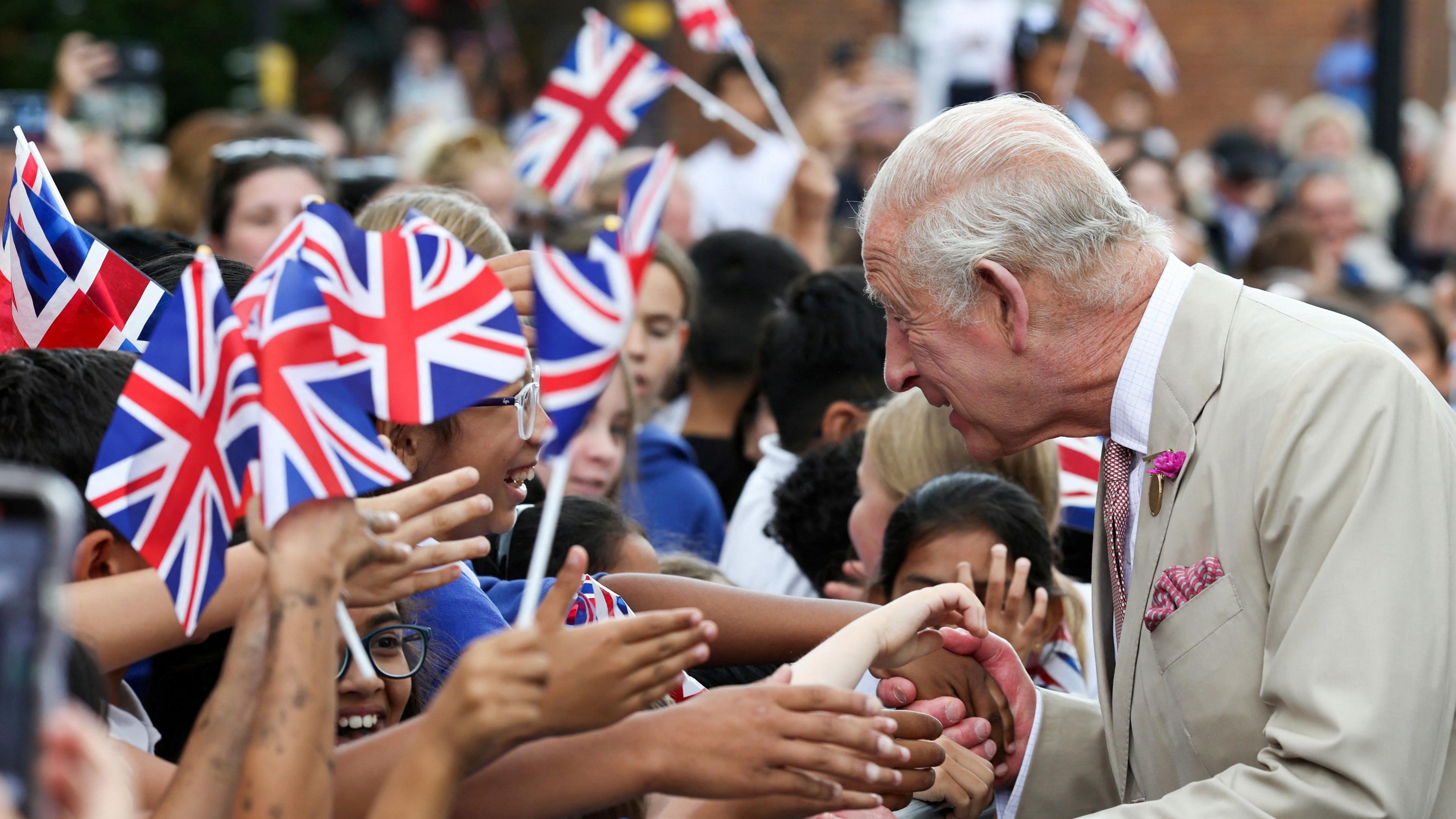 King Charles shakes the hands of people in Newmarket.