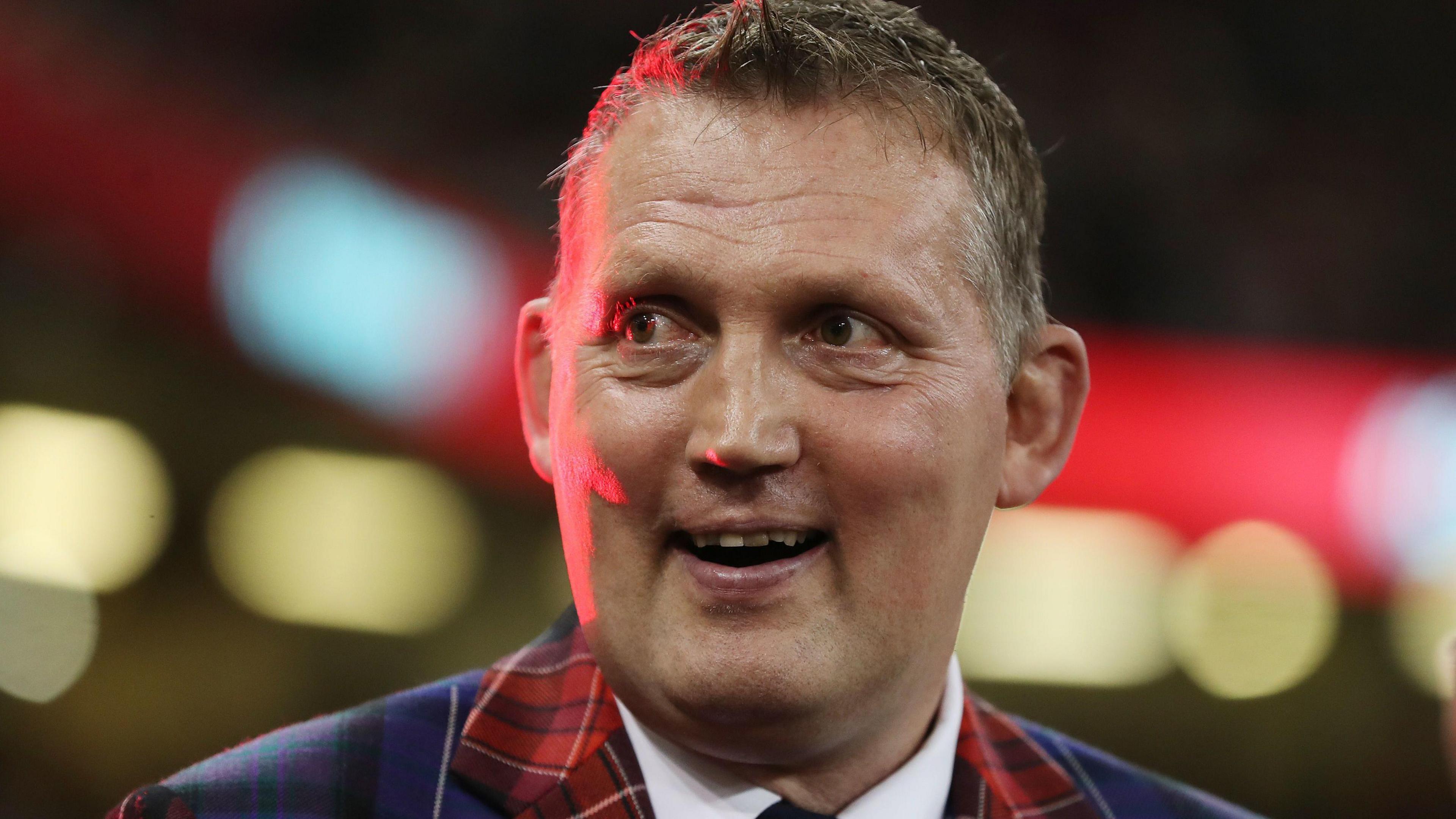 Doddie Wier wearing a tartan jacket and smiling 