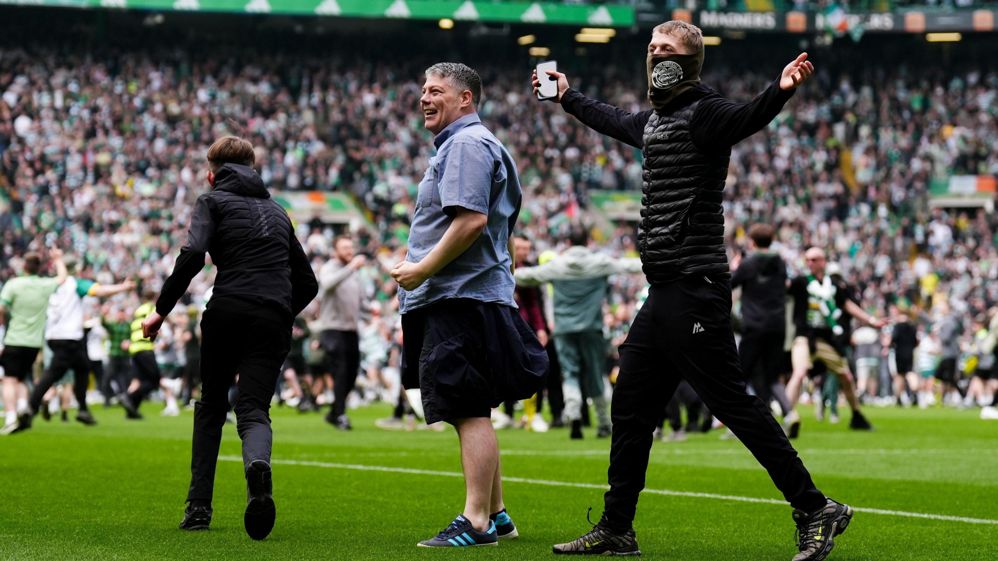 Celtic supporters invaded the pitch after their team clinched the league title against Hearts