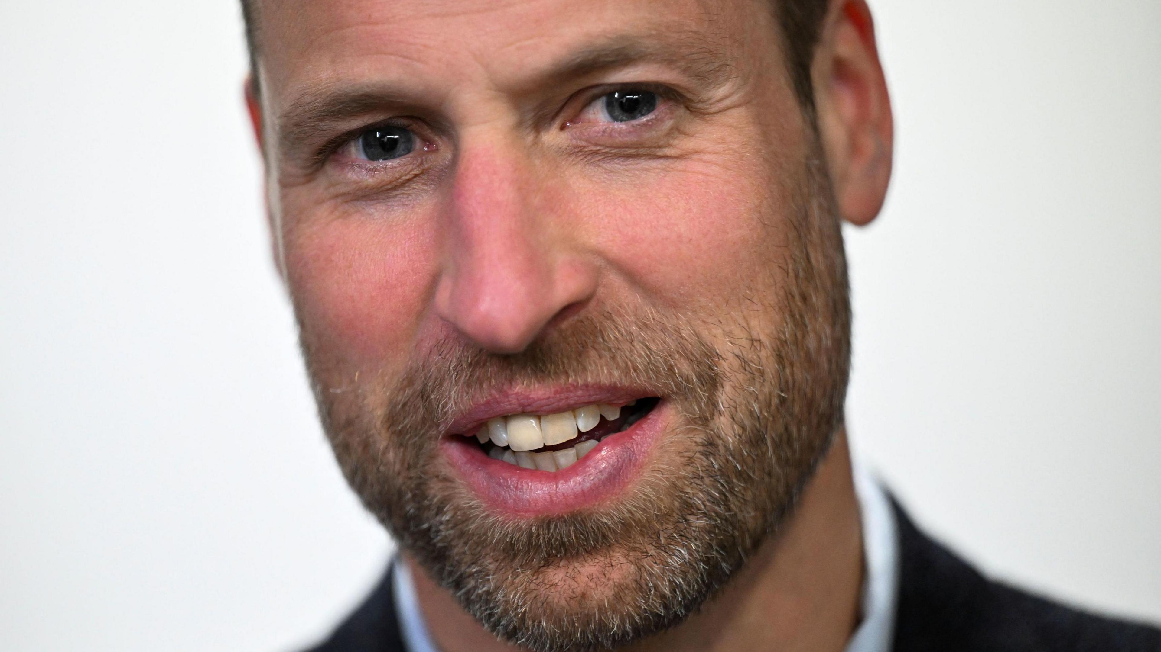 Prince William head and shoulders, wearing a beard.