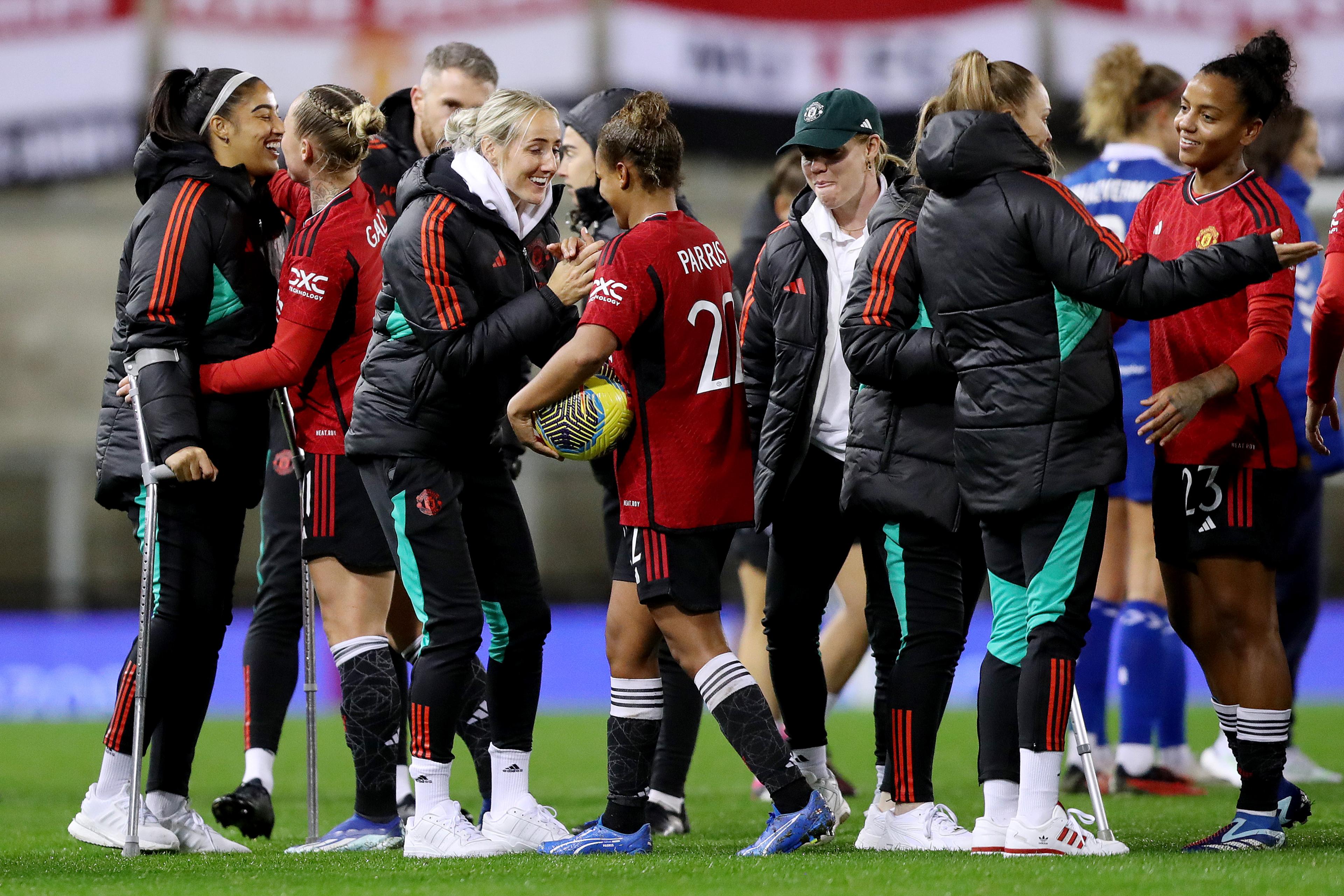 Nikita Parris carries the match ball while speaking to teammates on the pitch at full time.