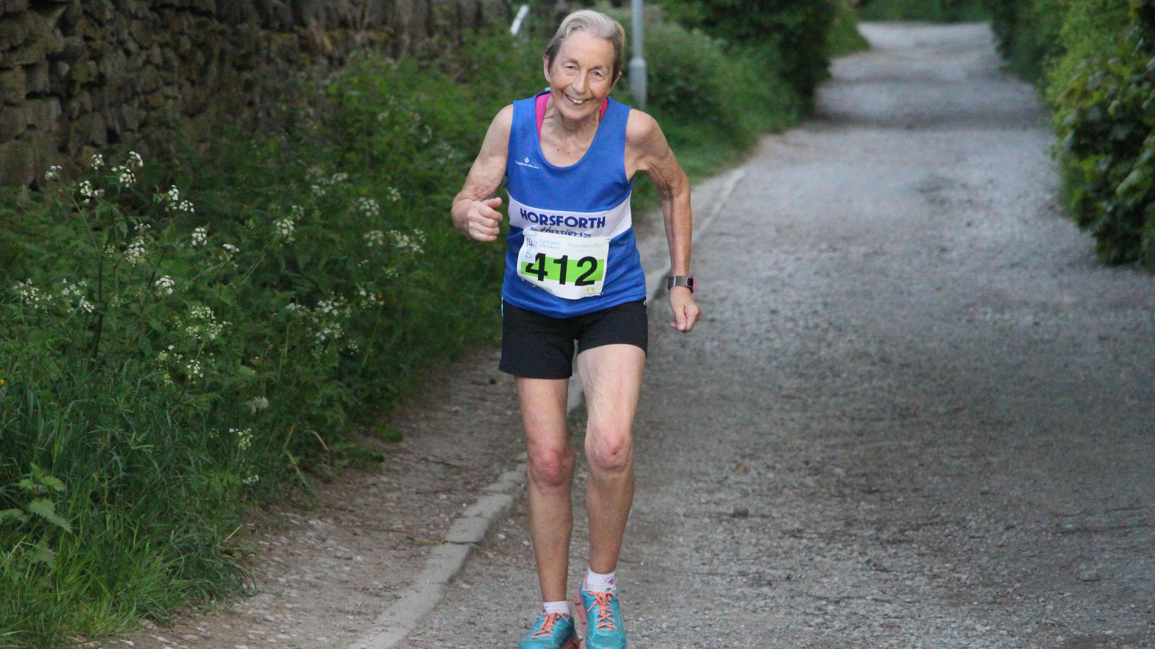 Hilary Wharam pictured running in a blue vest which reads Horsforth Harriers.