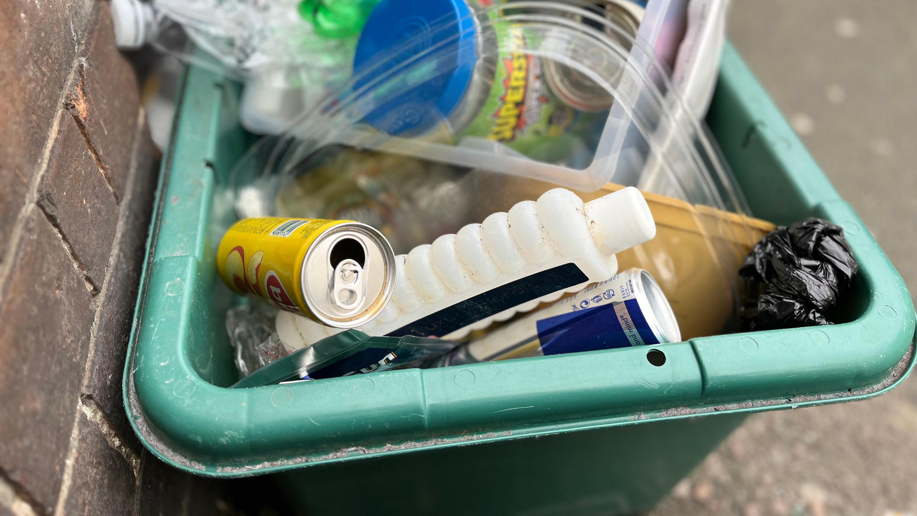 Mixed recycling on the pavement in a green box