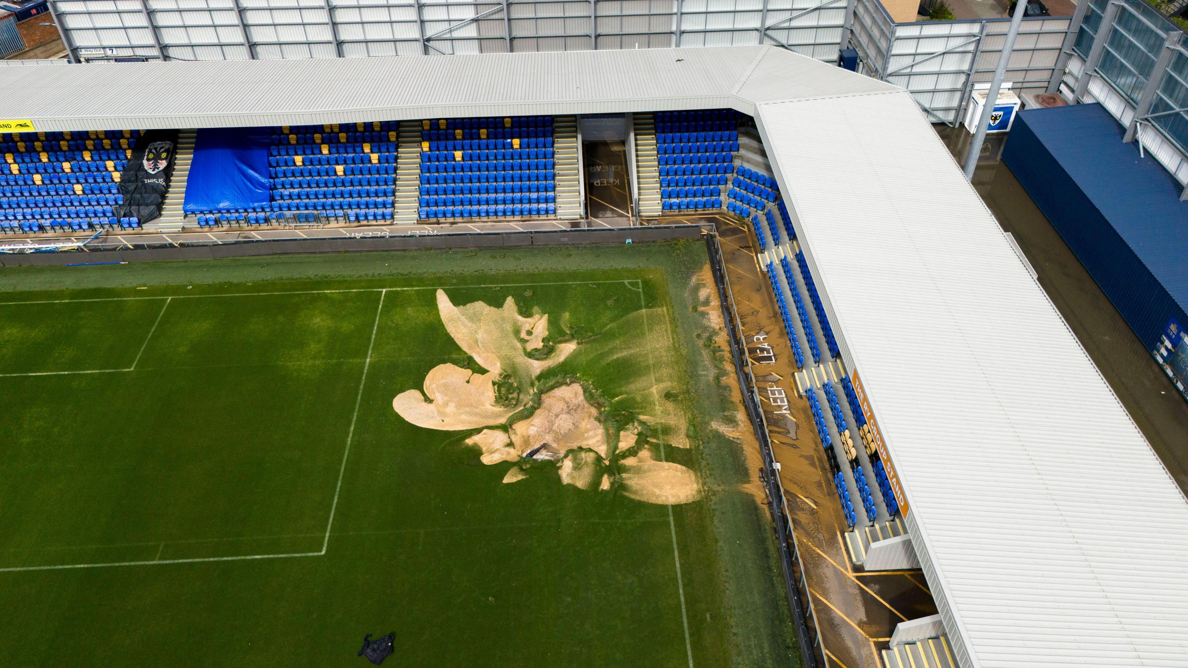 The corner of AFC Wimbledon's pitch where a sink hole has opened up. It's a sandy colour and takes up a big portion of the corner