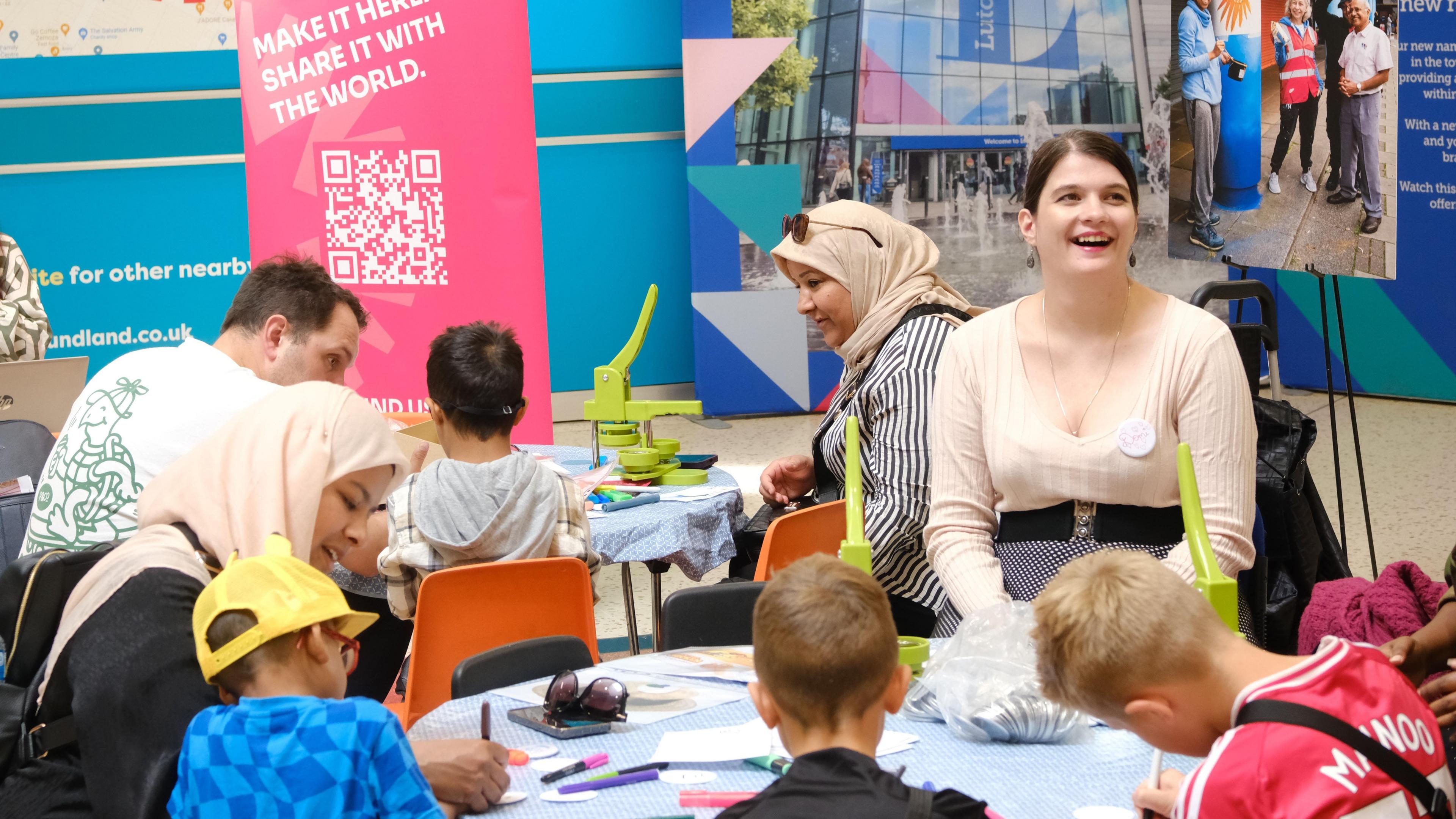 A number of children taking part in a badge making workshop in Luton