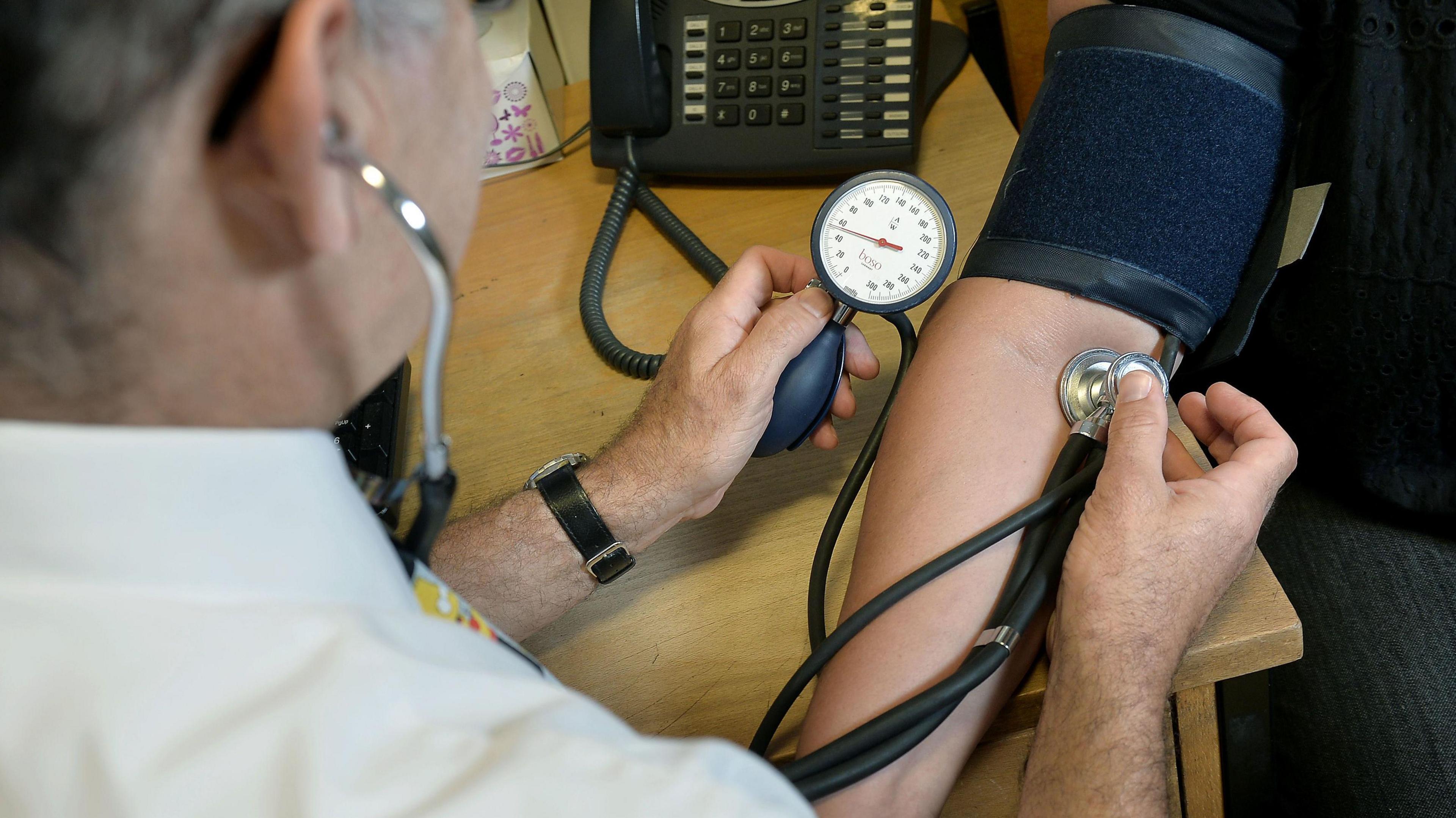 GP checking a patient's blood pressure