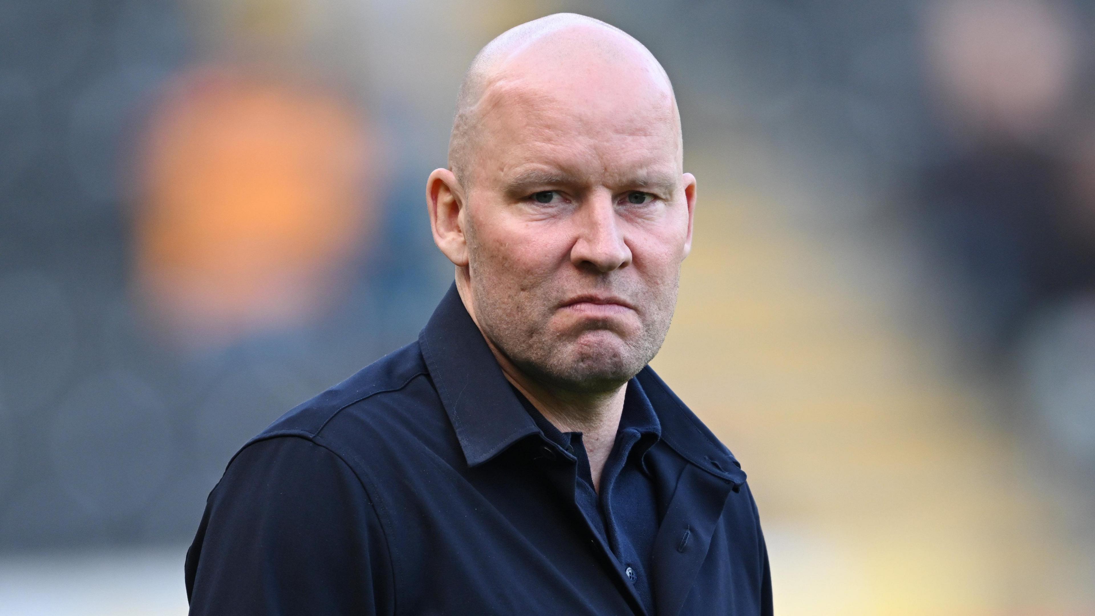 Henrik Pedersen, wearing a black jacket, looks straight-faced while on the touchline during Sheffield Wednesday's game at Hull City on 21 March