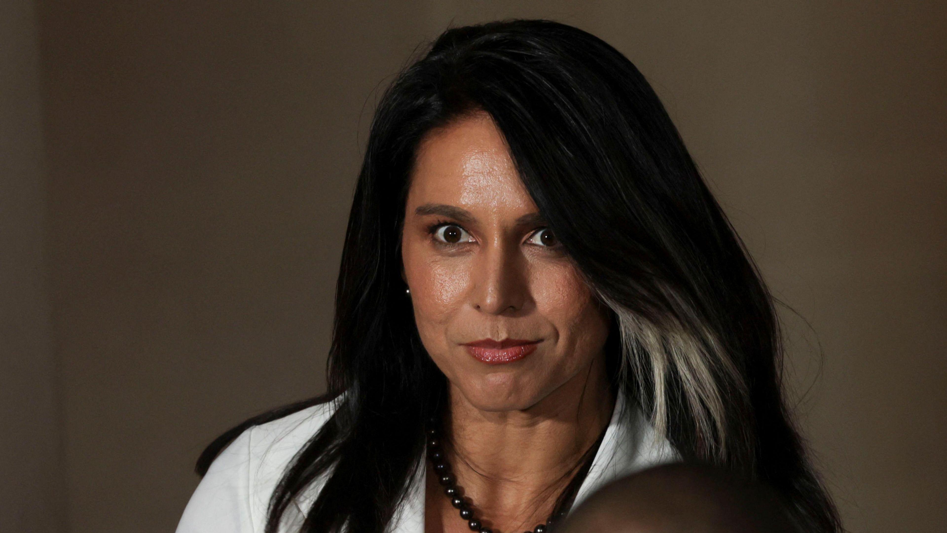 Tulsi Gabbard wearing a white top and black necklace.