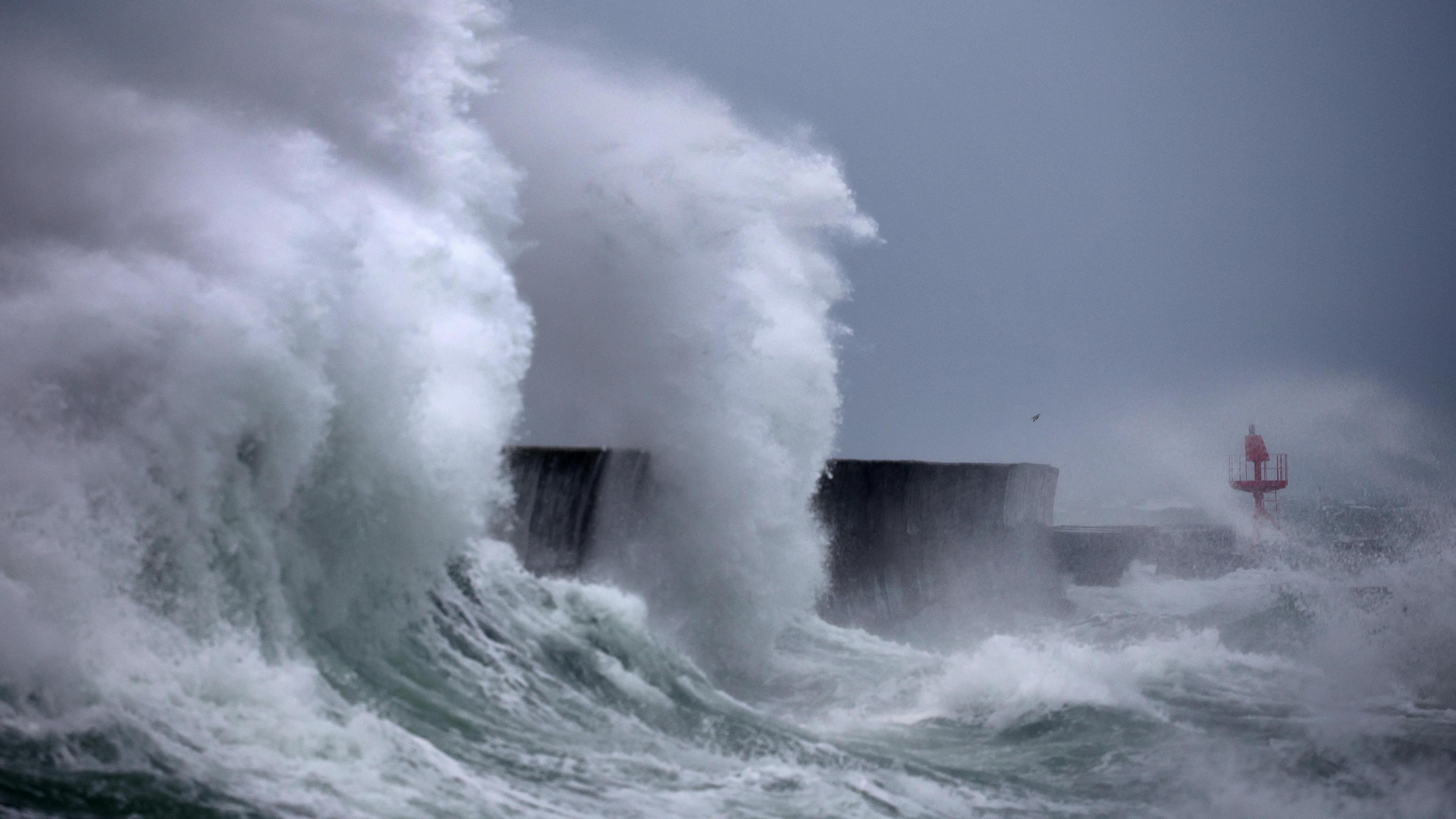 Large waves in western France spraying whitewash up high as it collides with a port