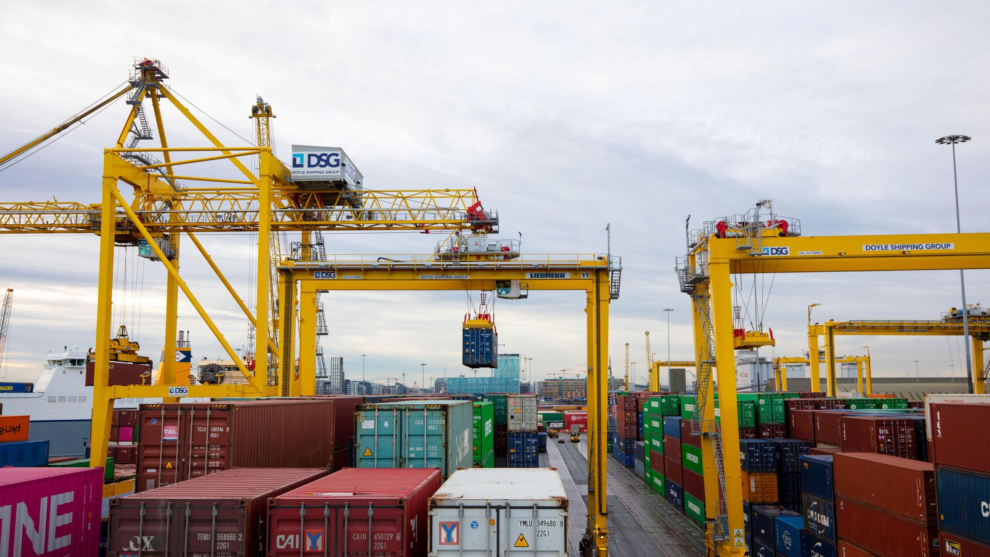 A port with large shipping containers of various sizes and colours