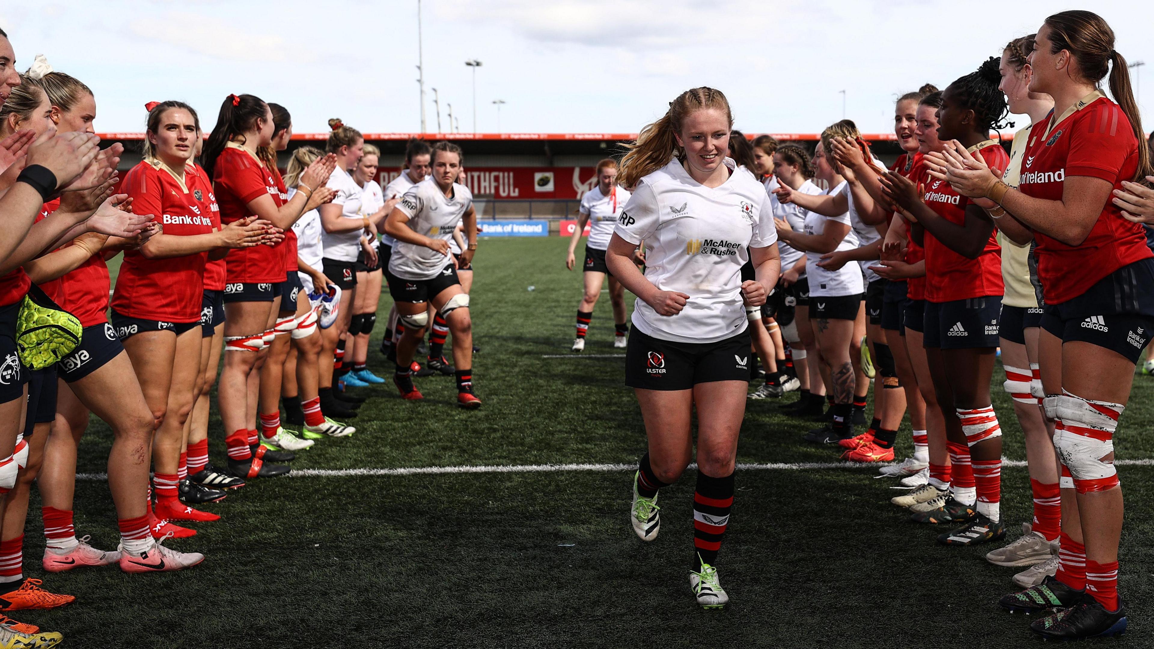 Kathryn Dane leads Ulster off the pitch against Munster