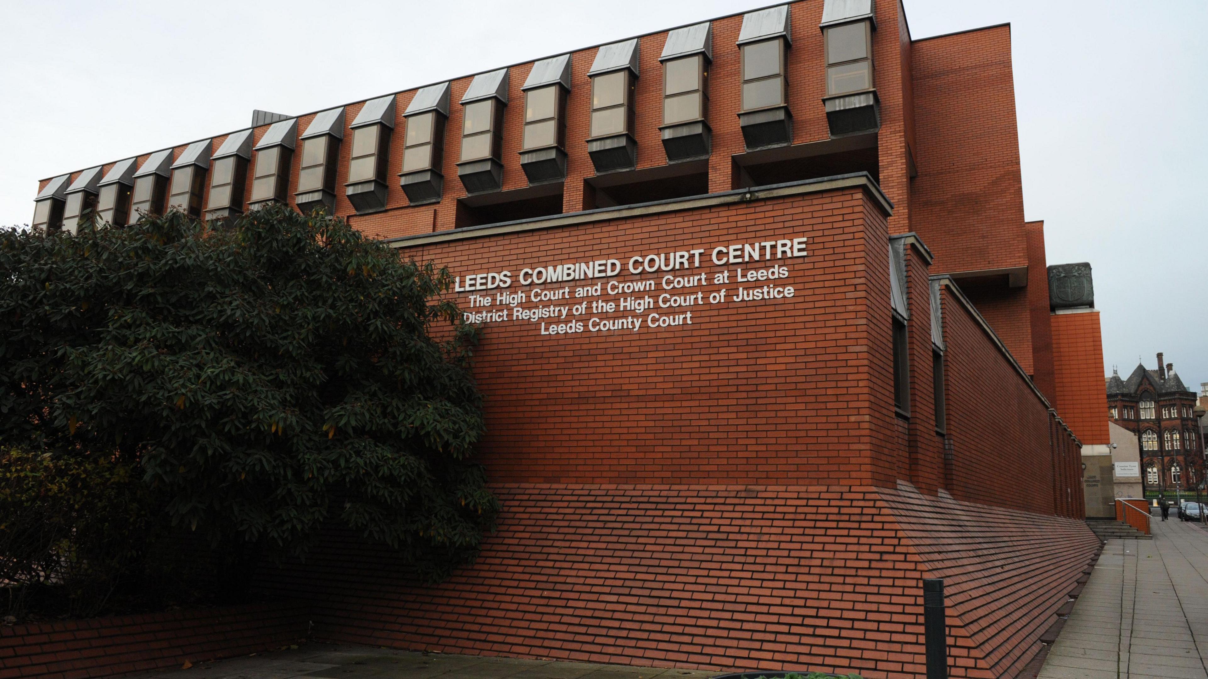 The outside of Leeds Crown Court, a red-brick, multi-storey building.