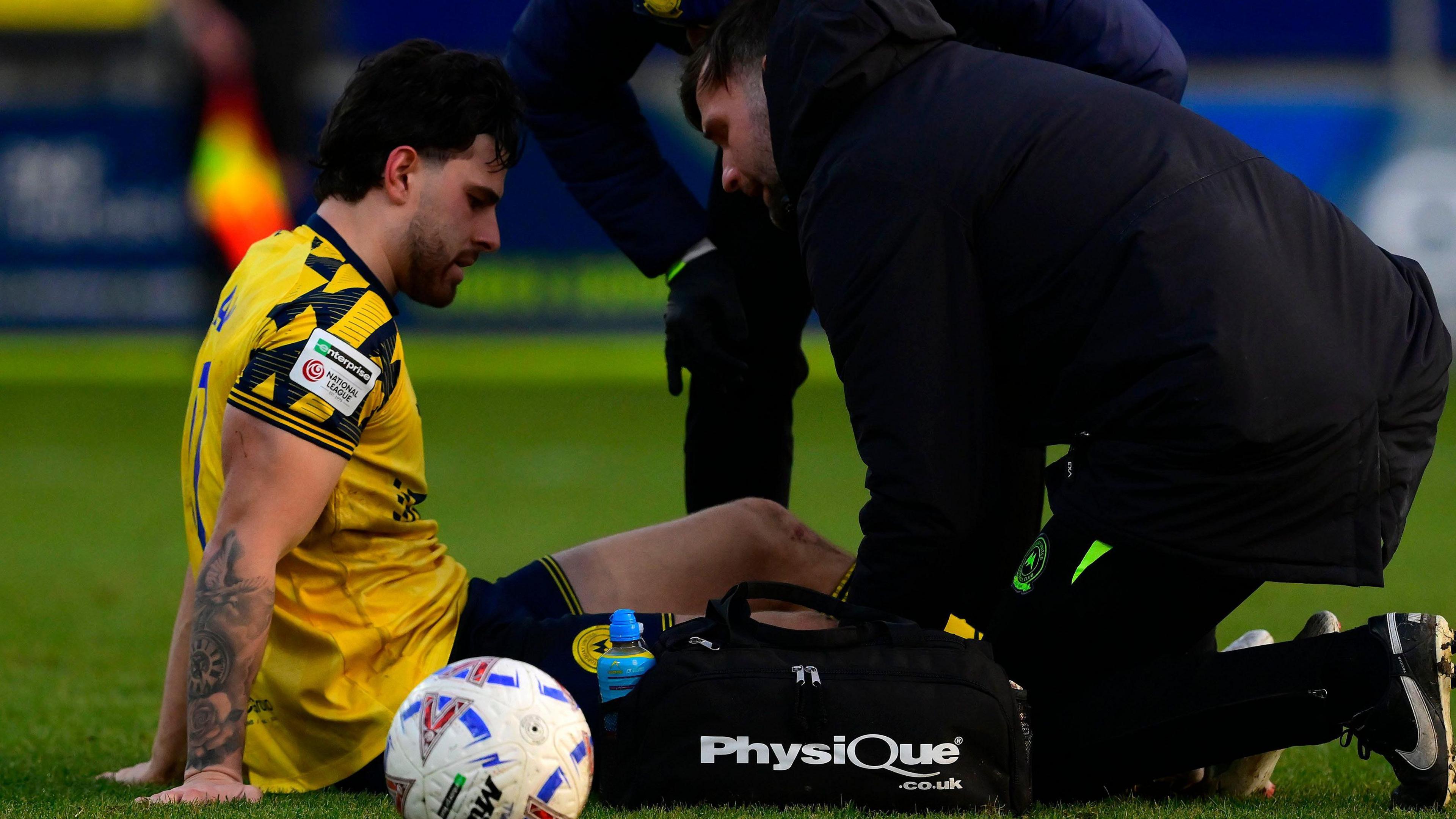 Callum Dolan is attended two by medics after being injured