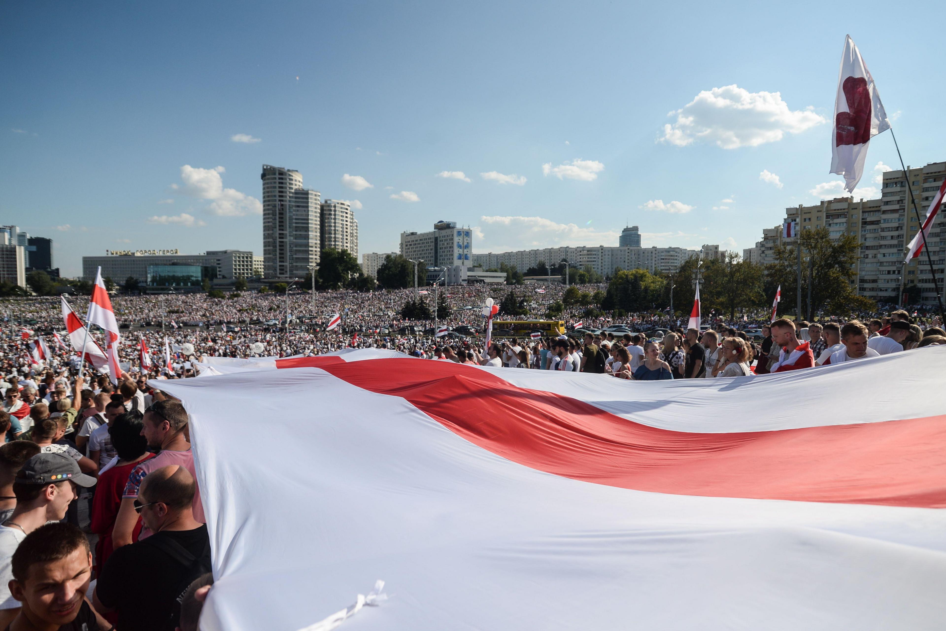 A huge crowd of people holding the historical flag of Belarus in Minsk on the 16th of August 2020.  