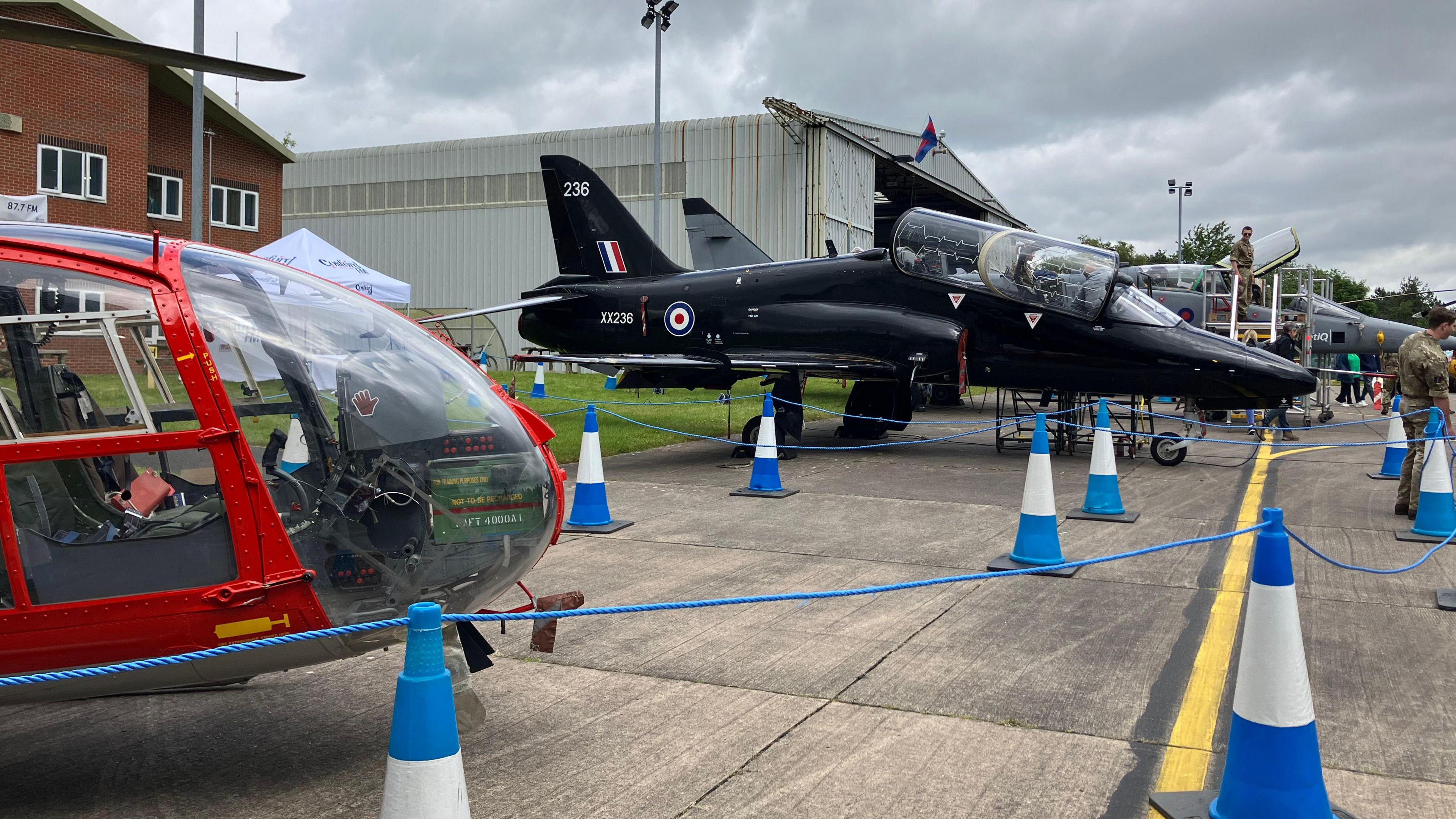 Aircraft taking part in Cosford air show in 2024 are on the ground and surrounded by blue and white cones and blue cordons at the air base.
