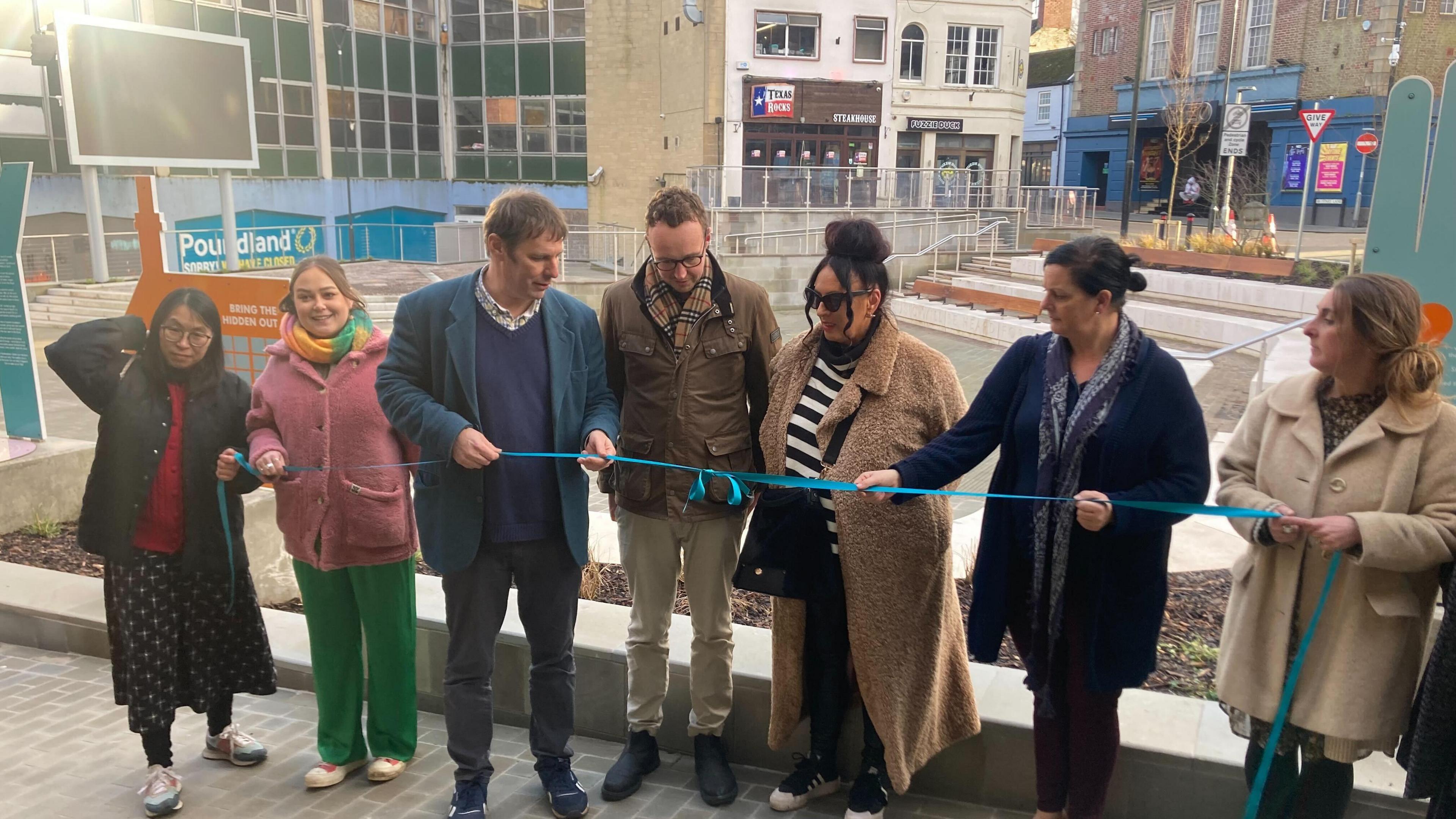 Adam Dance stands in the centre of a line of seven people who cut the ribbon at the unveiling of the new amphitheatre in Yeovil