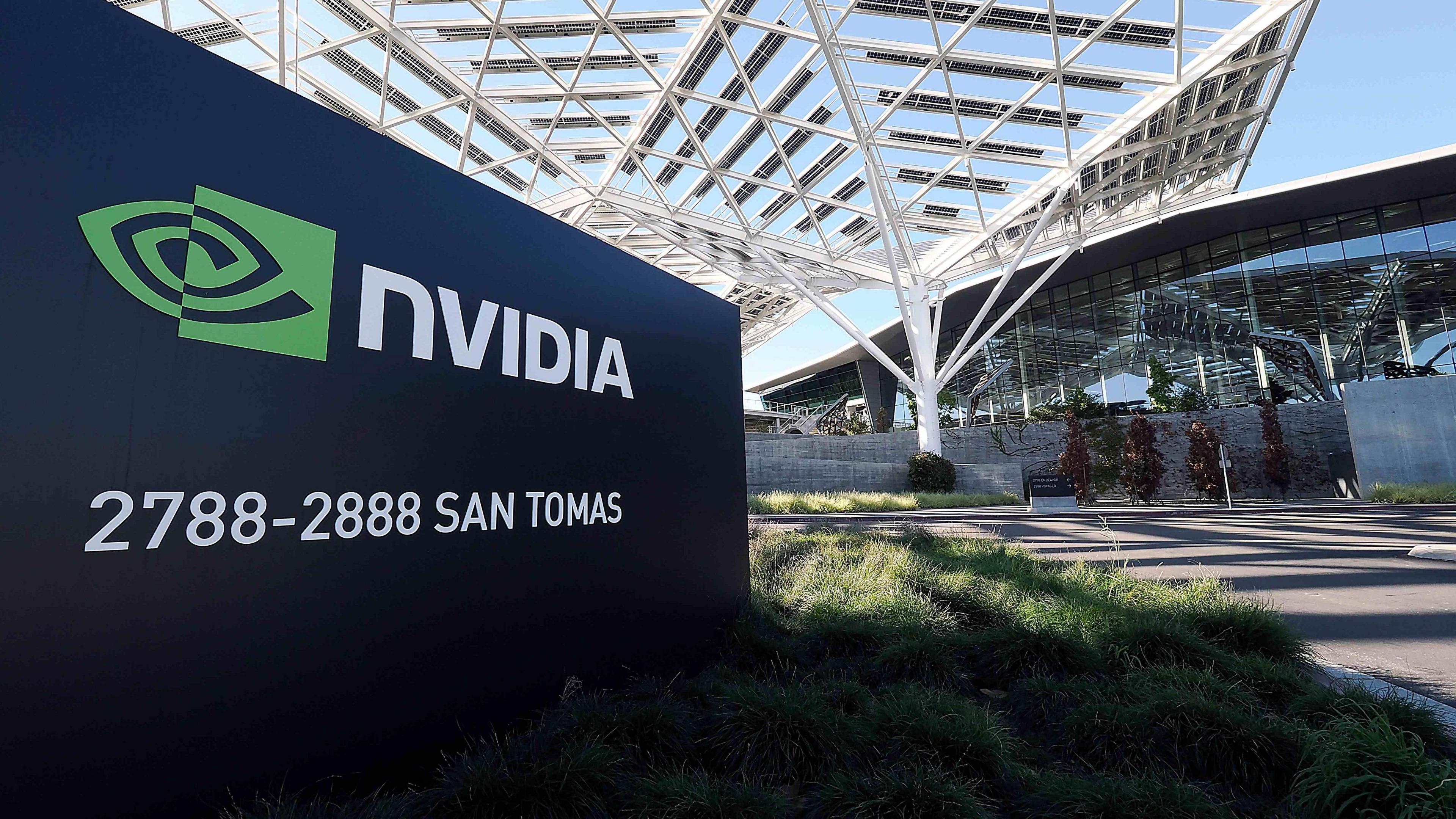 A sign reads "Nvidia" next to a green logo, in front of a modern building.