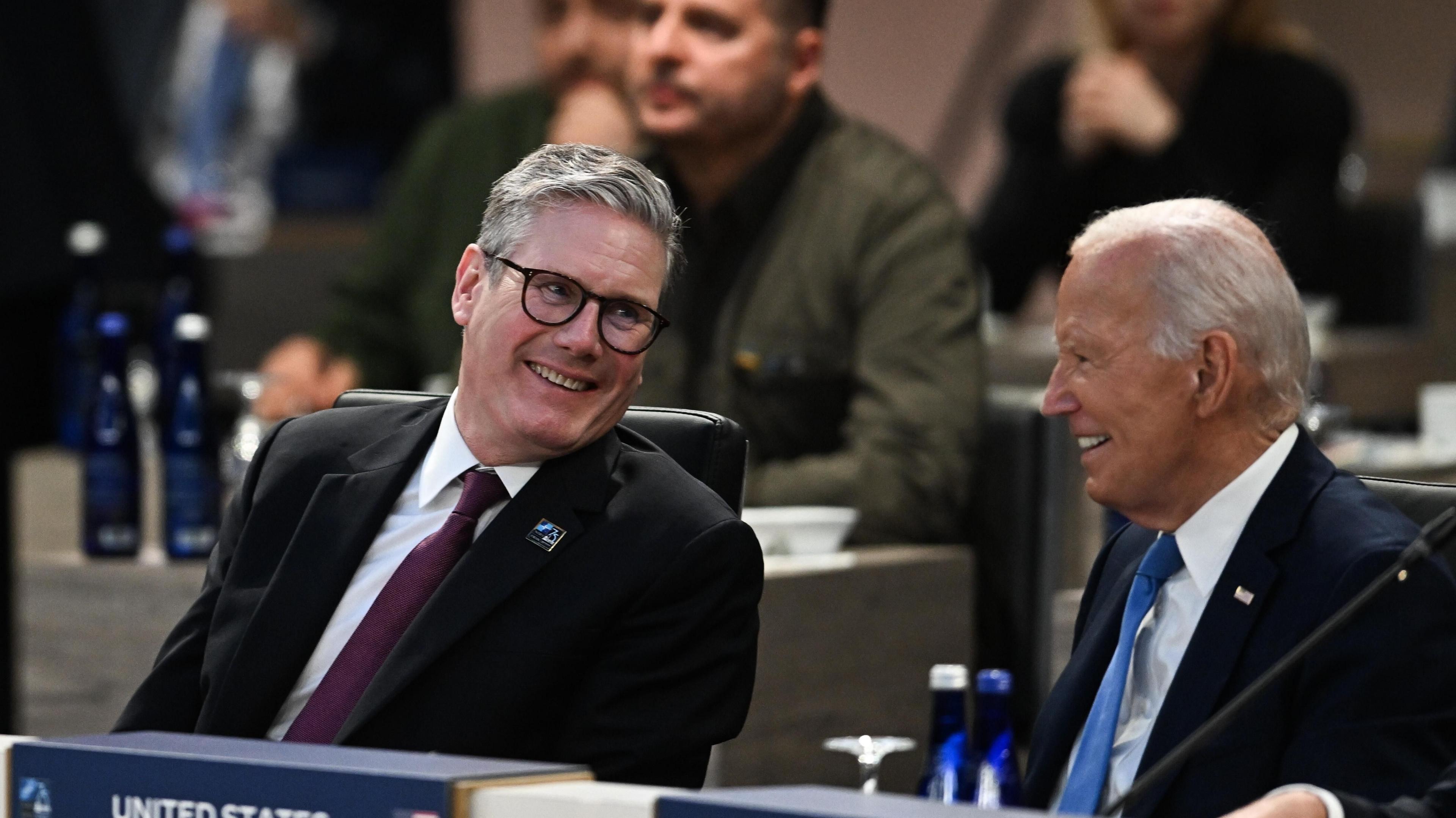 Prime Minister Keir Starmer and US President Joe Biden exchange words as they sit together at a meeting of the Nato-Ukraine Council during the Nato summit