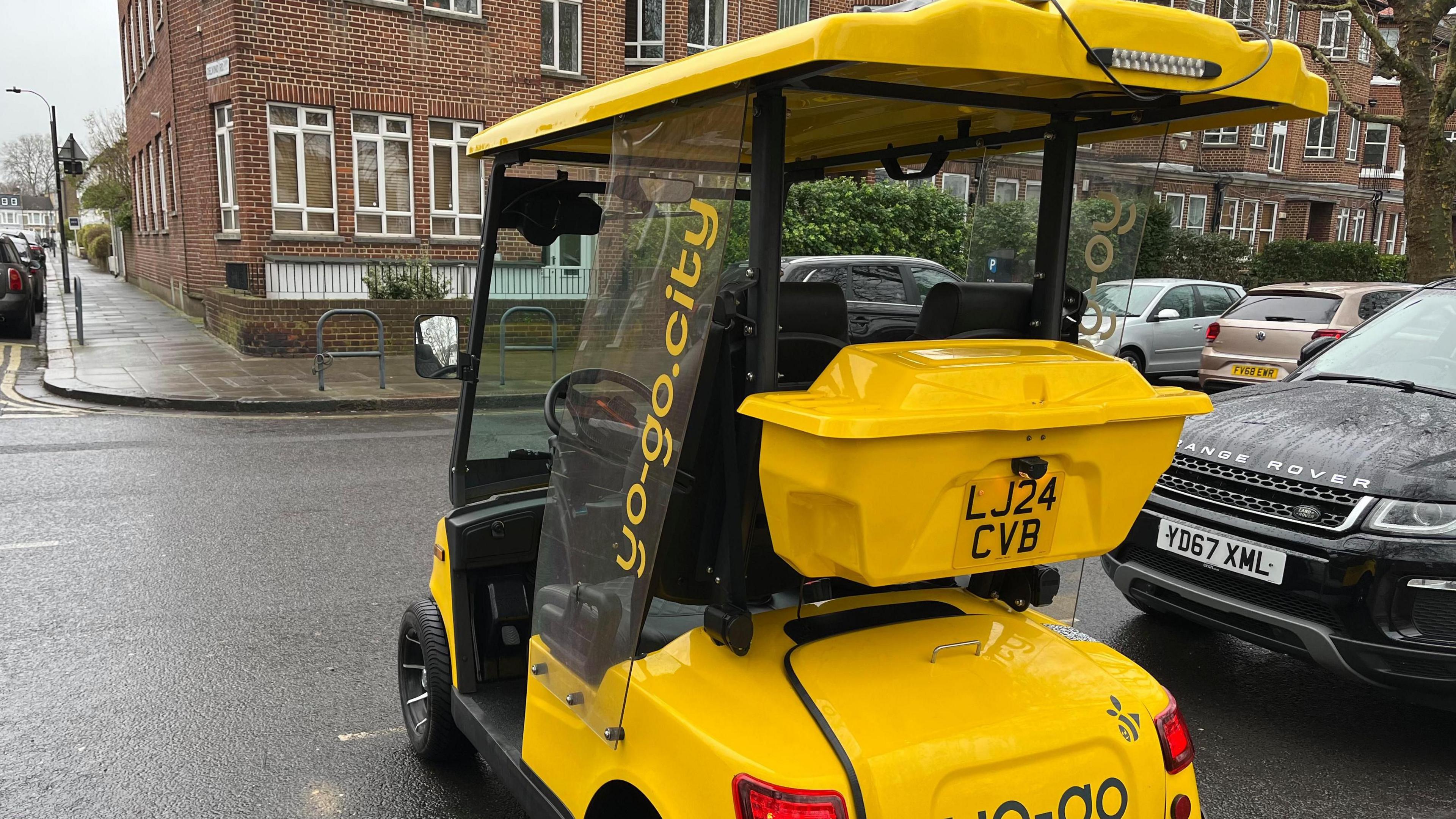 A yellow buggy is parked in a road