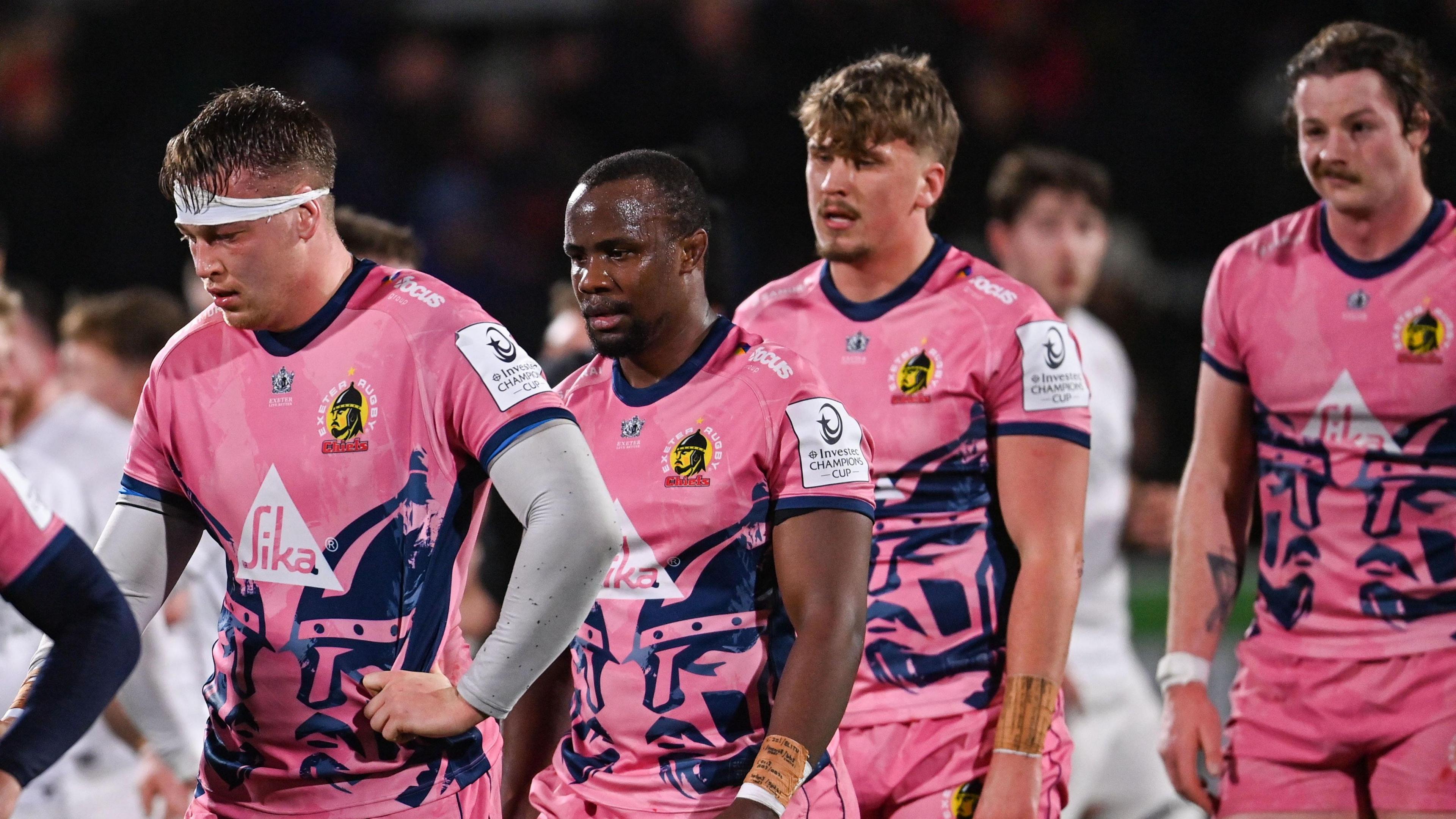 Exeter players leave the field looking dejected