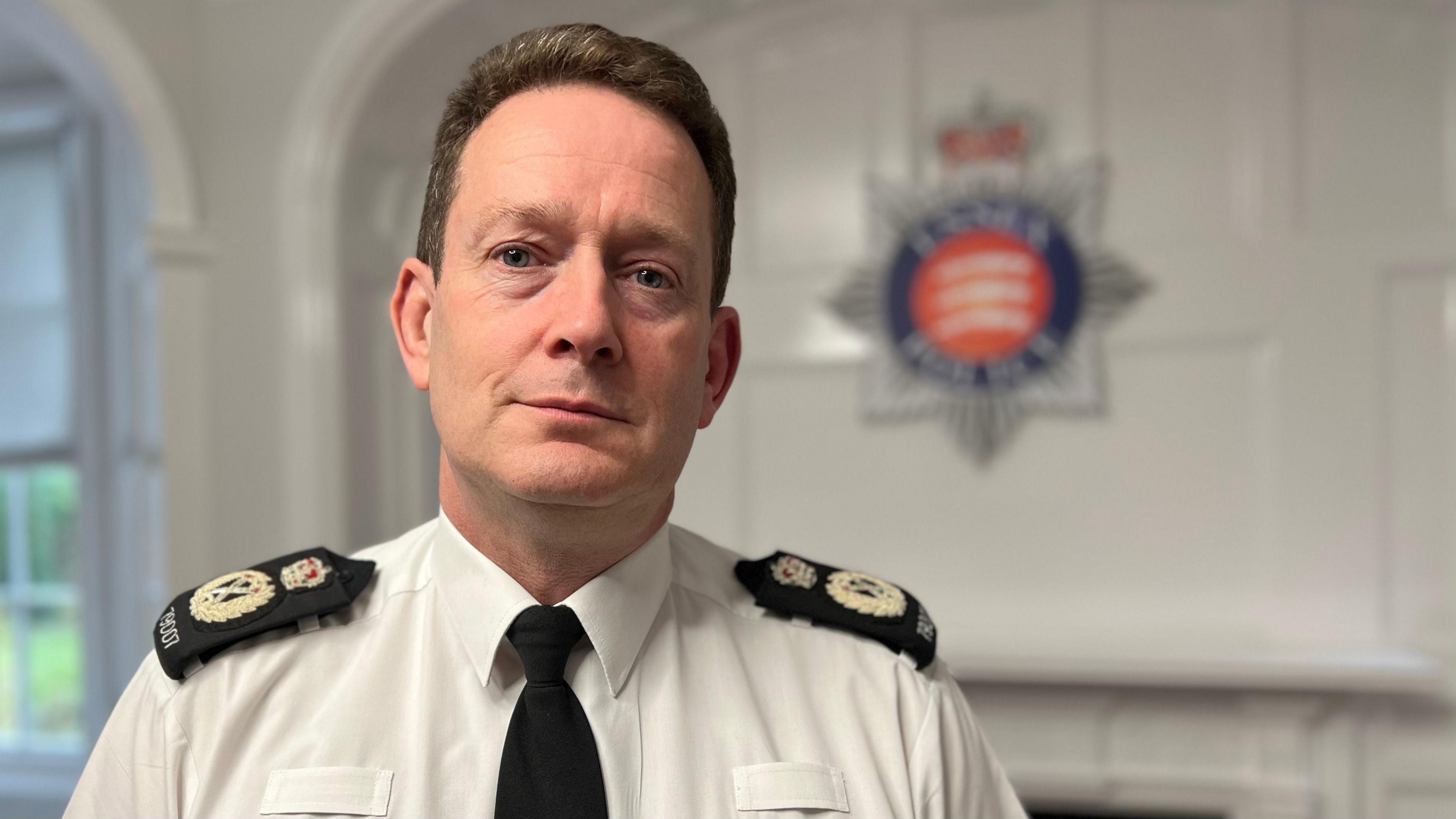 Ben-Julian Harrington pictured wearing a police uniform standing in police headquarters