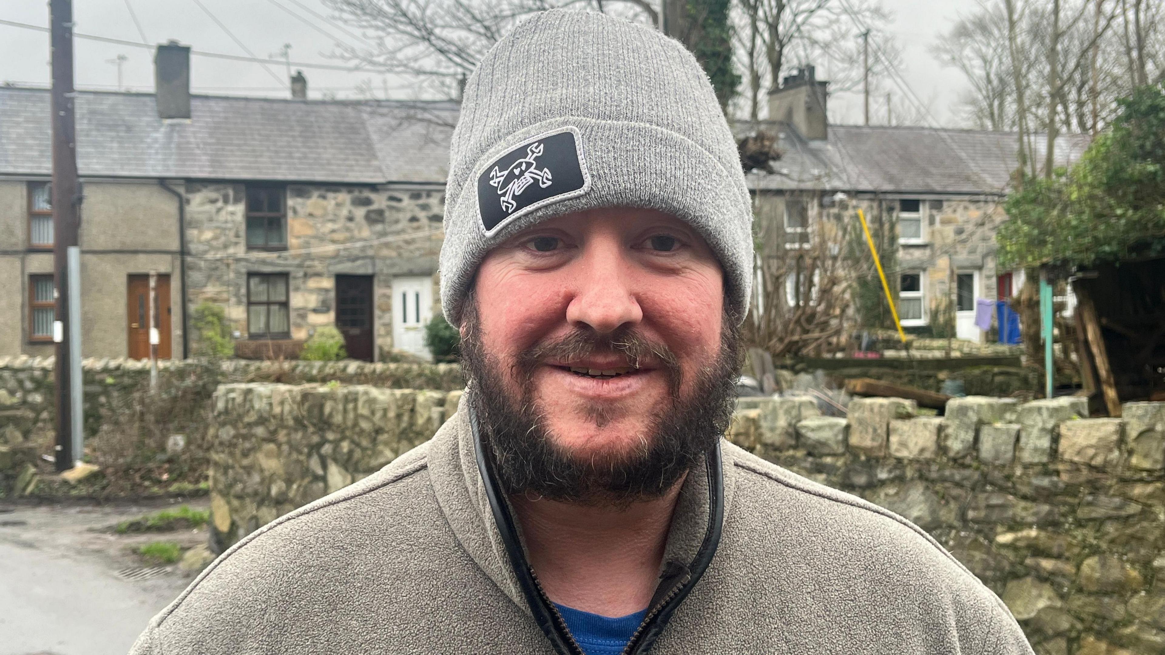 Malcolm Evans yn gwisgo cap.