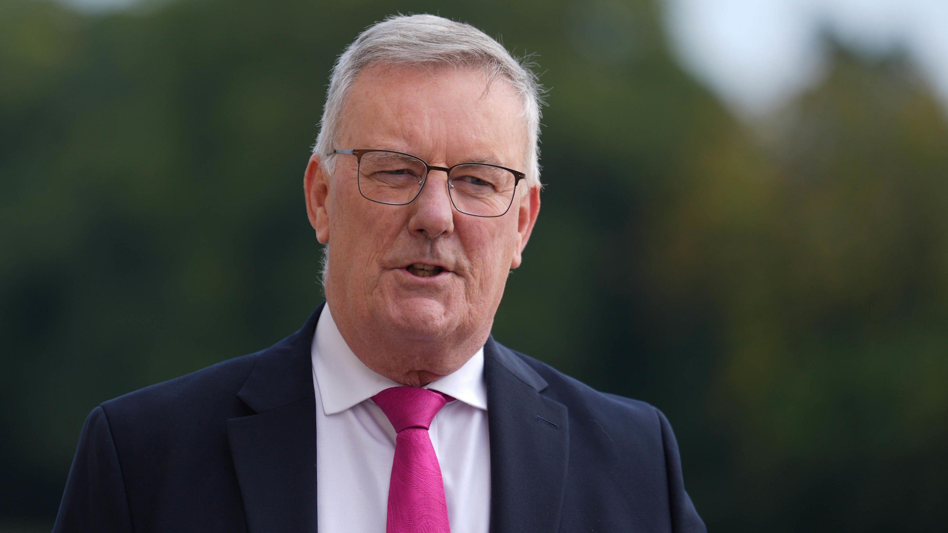 Mike Nesbitt in Navy suit with a pink tie 