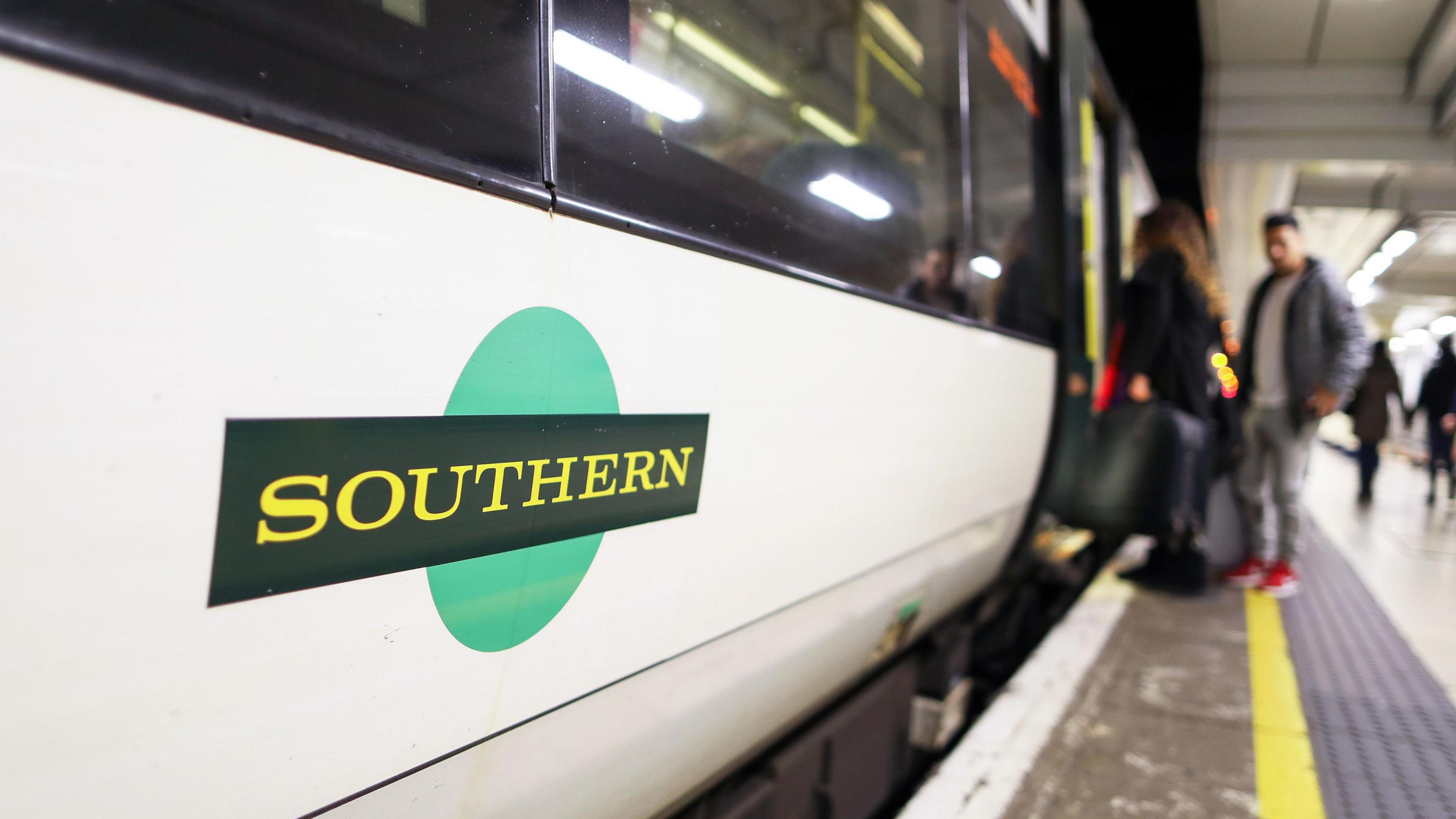 Southern train at a station with passengers boarding