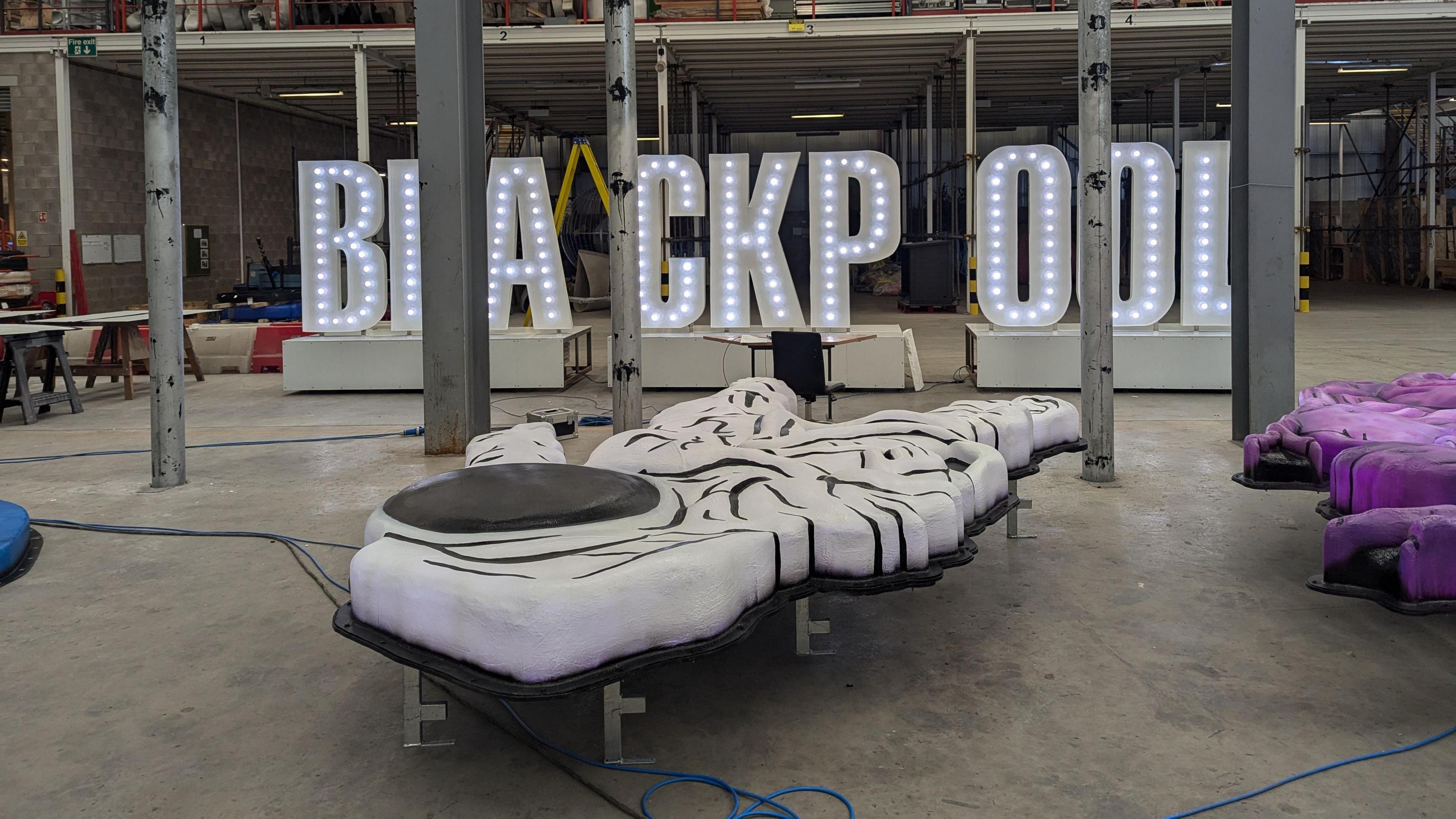 An light fixture in the middle of the factory that spells out Blackpool