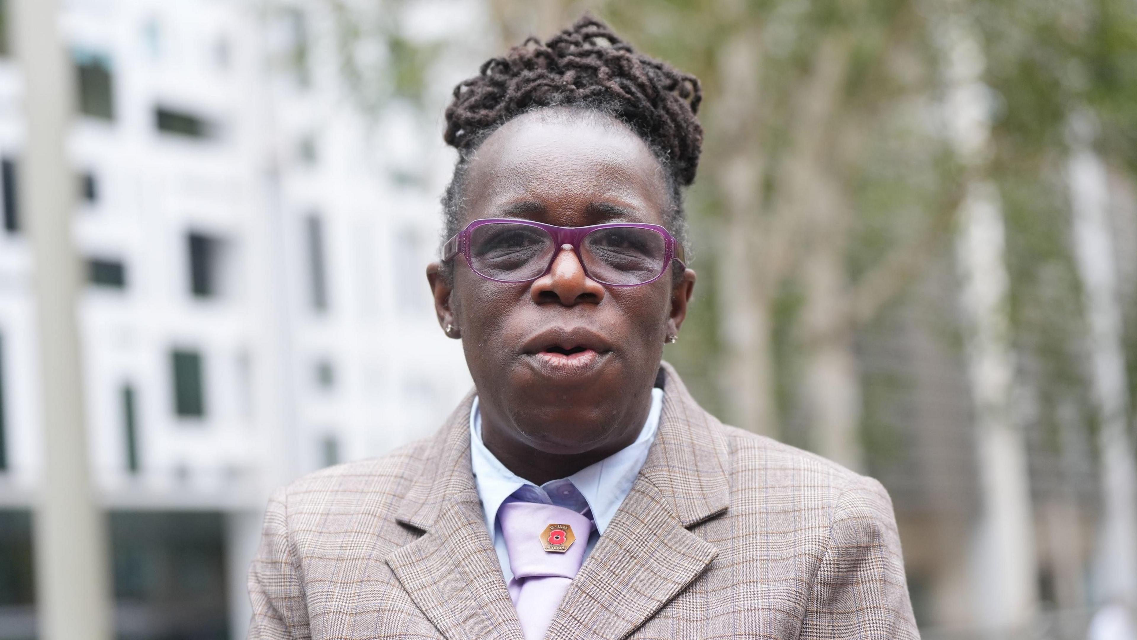 Ms Adoo-Kissi-Debrah in a suit jacket, pink tie and white shirt. 