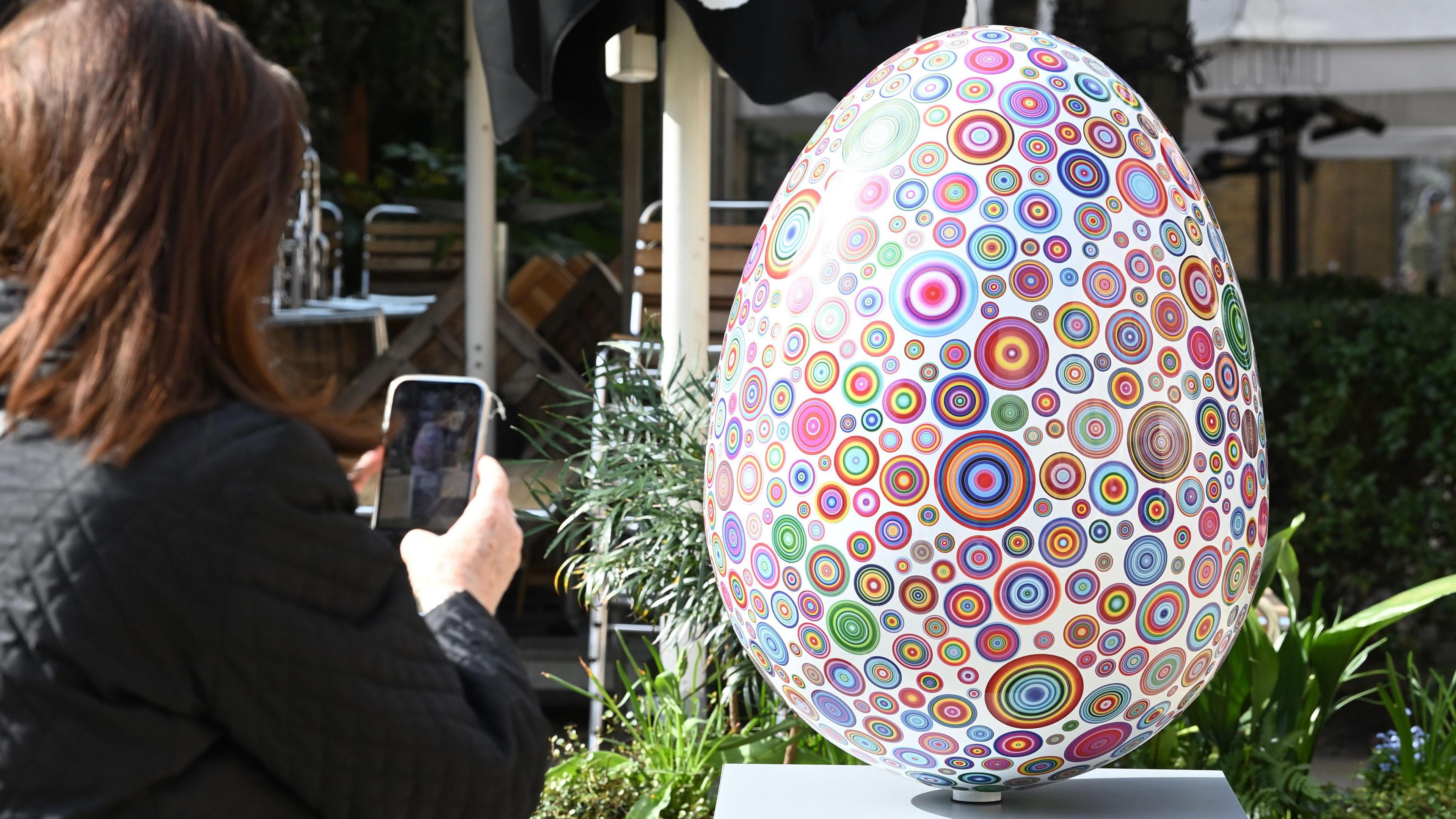 A psychedelic egg with colourful, circular pattens. 