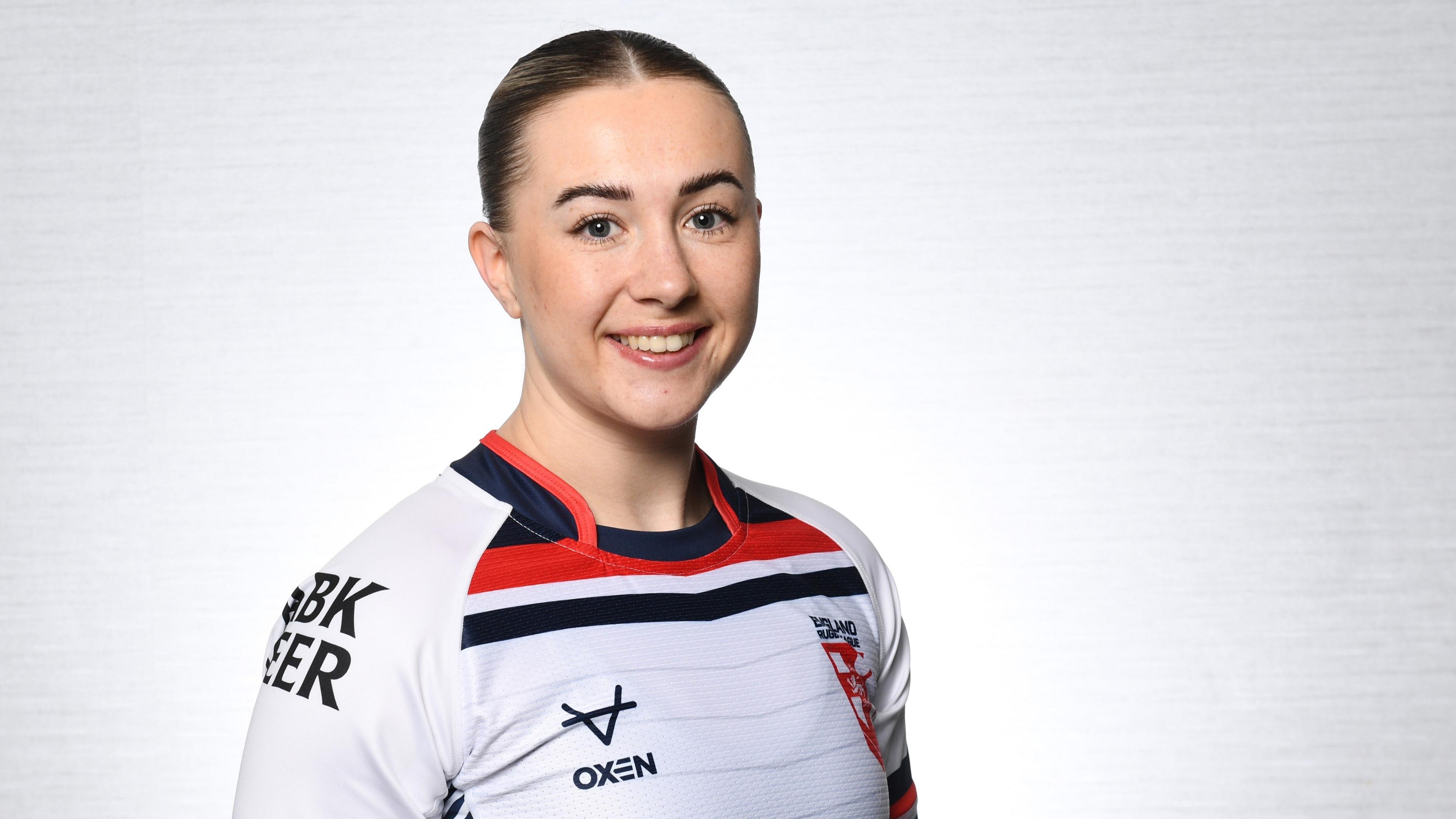 Georgie Dagger, in an England shirt, smiling at the camera