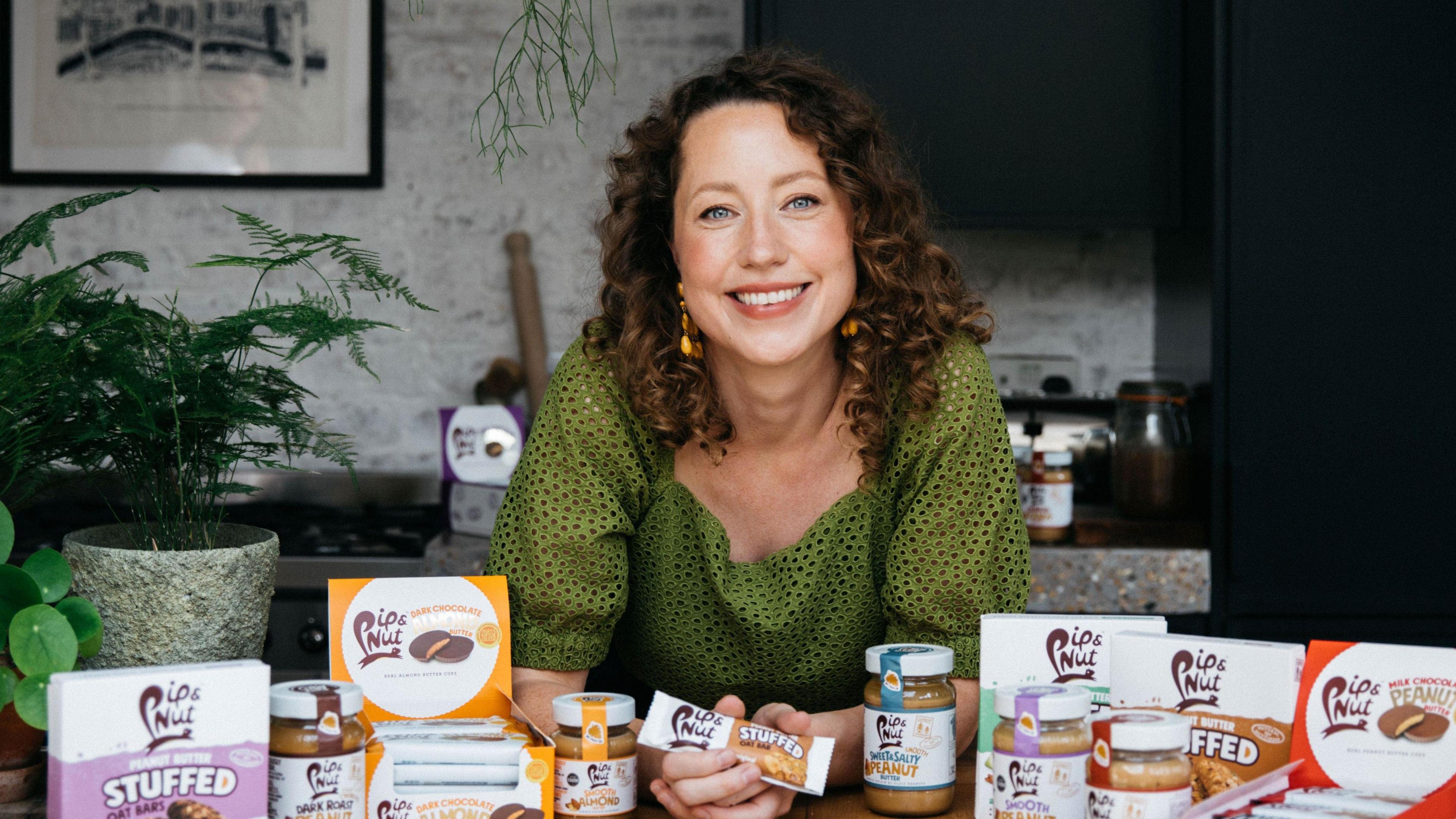 Pip Murray sitting down at a desk surrounded by her products