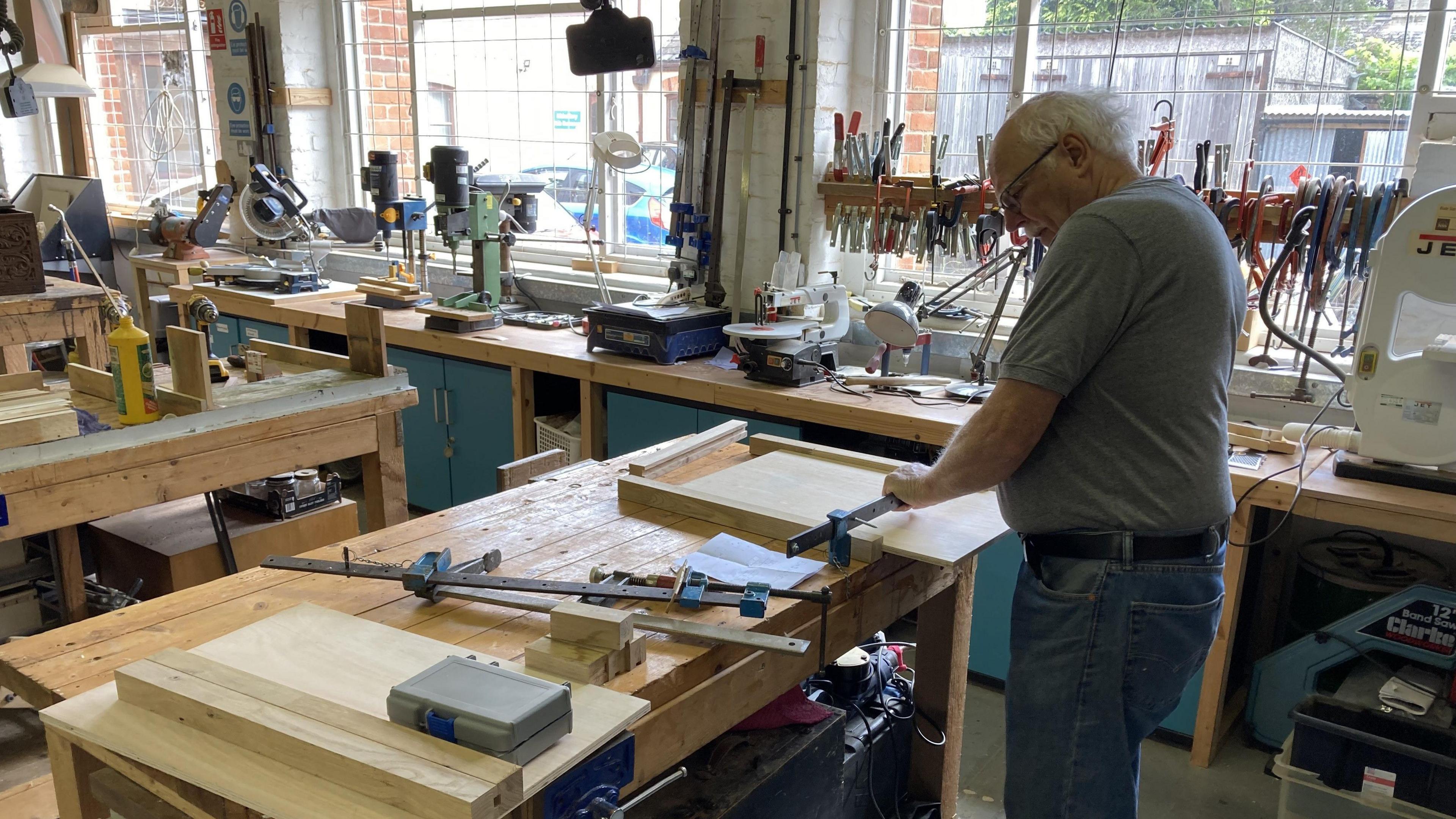 A man making use of the Halesworth Men's Shed's woodwork equipment